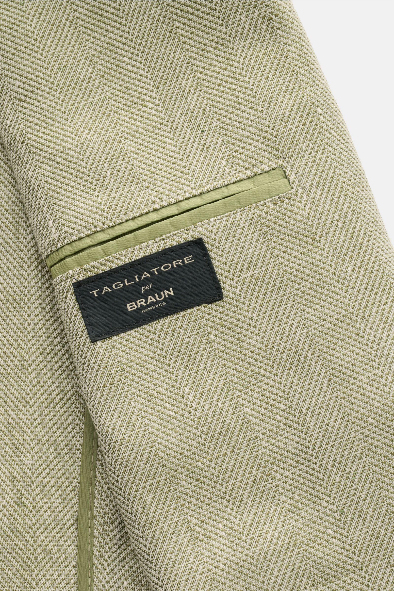 Nahaufnahme des Innenfutters vom Tagliatore Sakko 'Monte Carlo' oliv meliert mit Fischgrat-Struktur, Label und grüner Paspel.