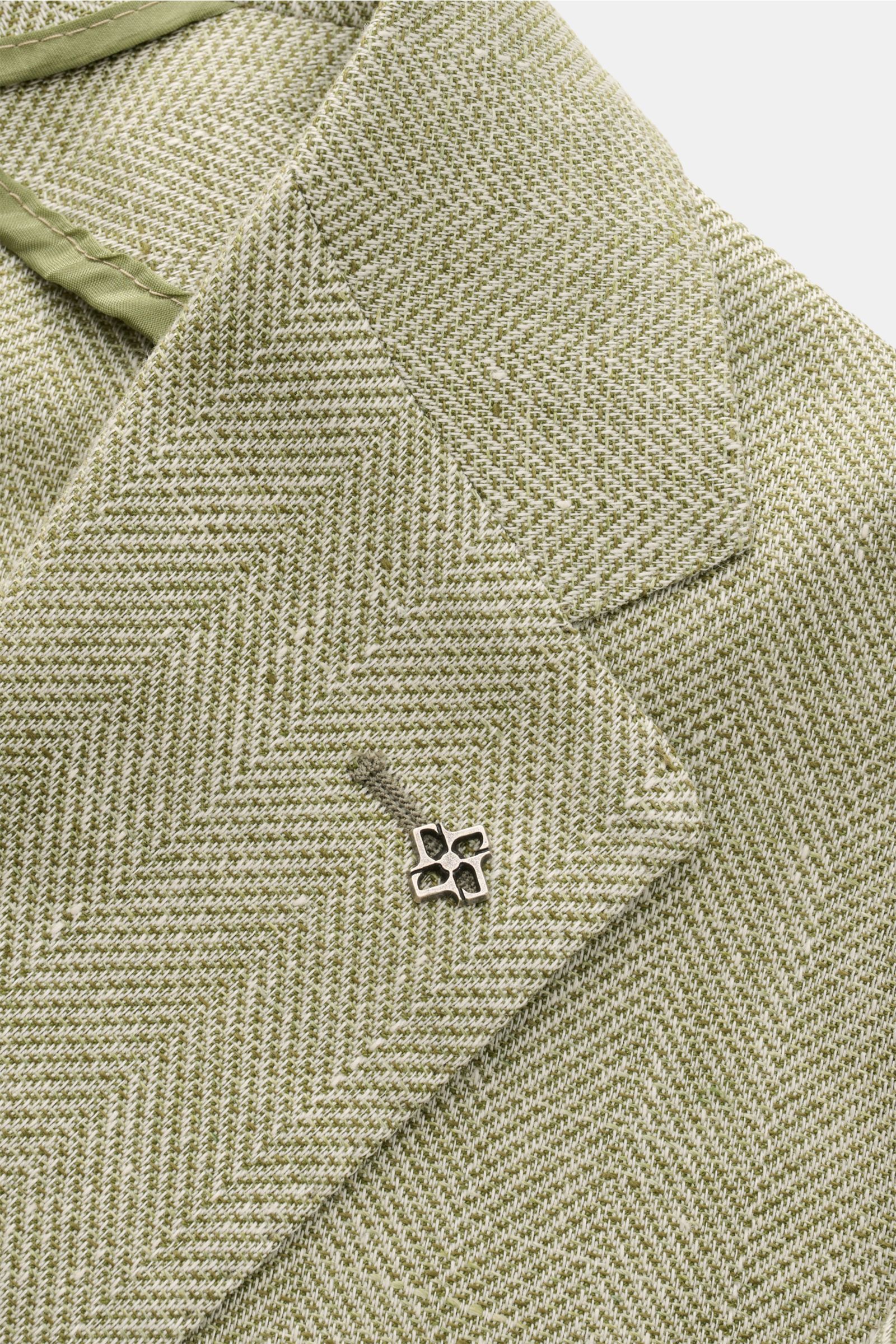 Tagliatore Sakko 'Monte Carlo' oliv meliert in Nahaufnahme von schräg oben, zeigt Fischgrat-Struktur, fallendes Revers und markanten Pin.