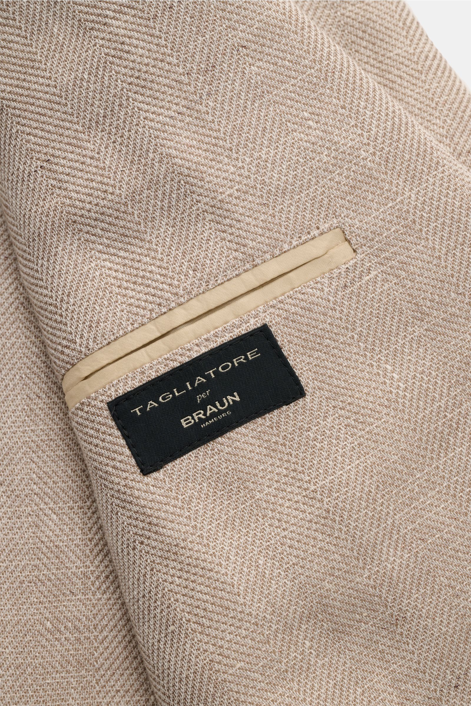 Close-up front detail of Tagliatore Smart-casual jacket 'Monte Carlo' beige mottled showing herringbone linen-cotton blend and label.

