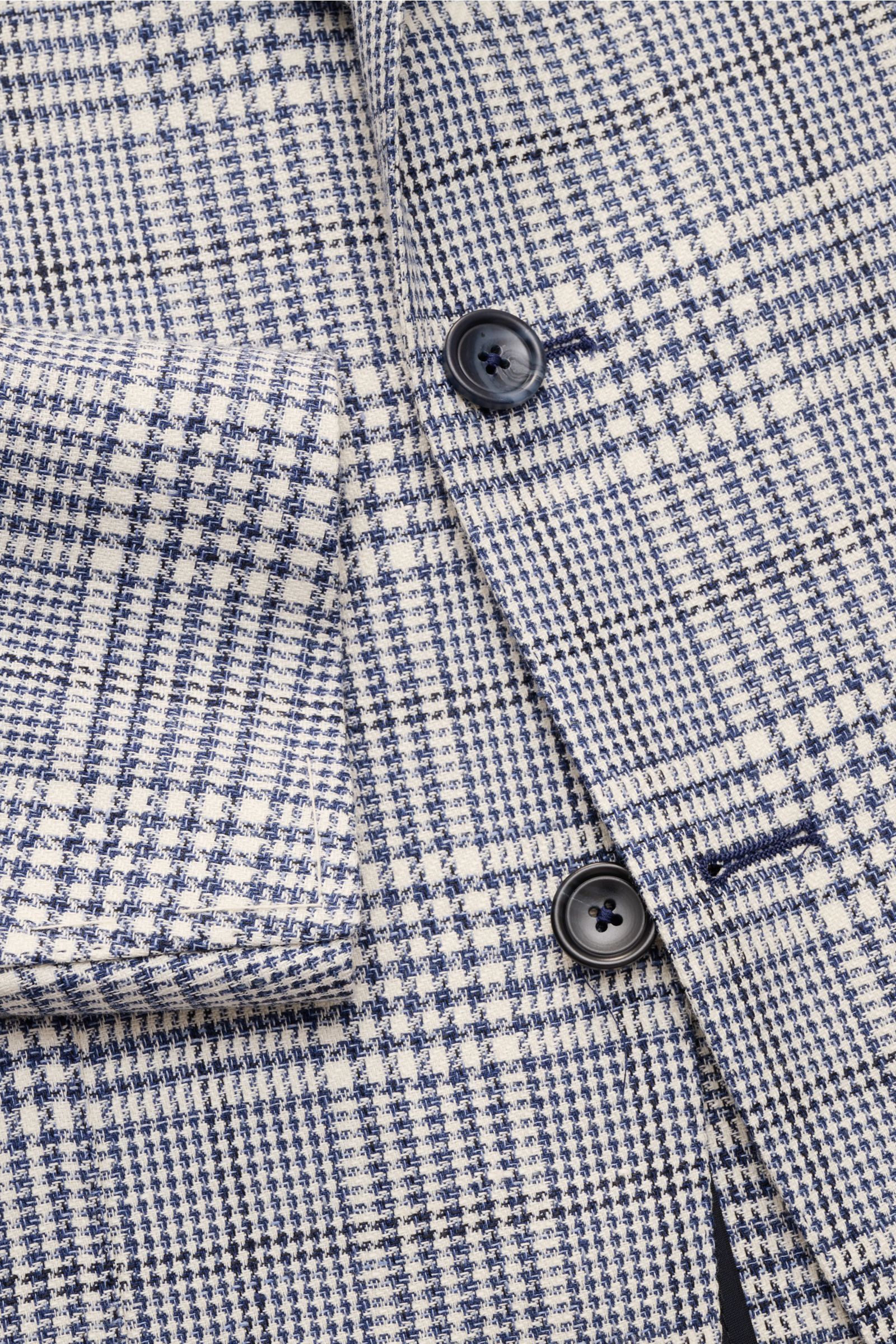 Close-up front view of Tagliatore Smart-casual jacket 'Monte Carlo' dark blue/cream checked, showing linen-cotton Glen check fabric, two-button slim fit, patch hip pocket, and unfinished sleeve cuffs. 