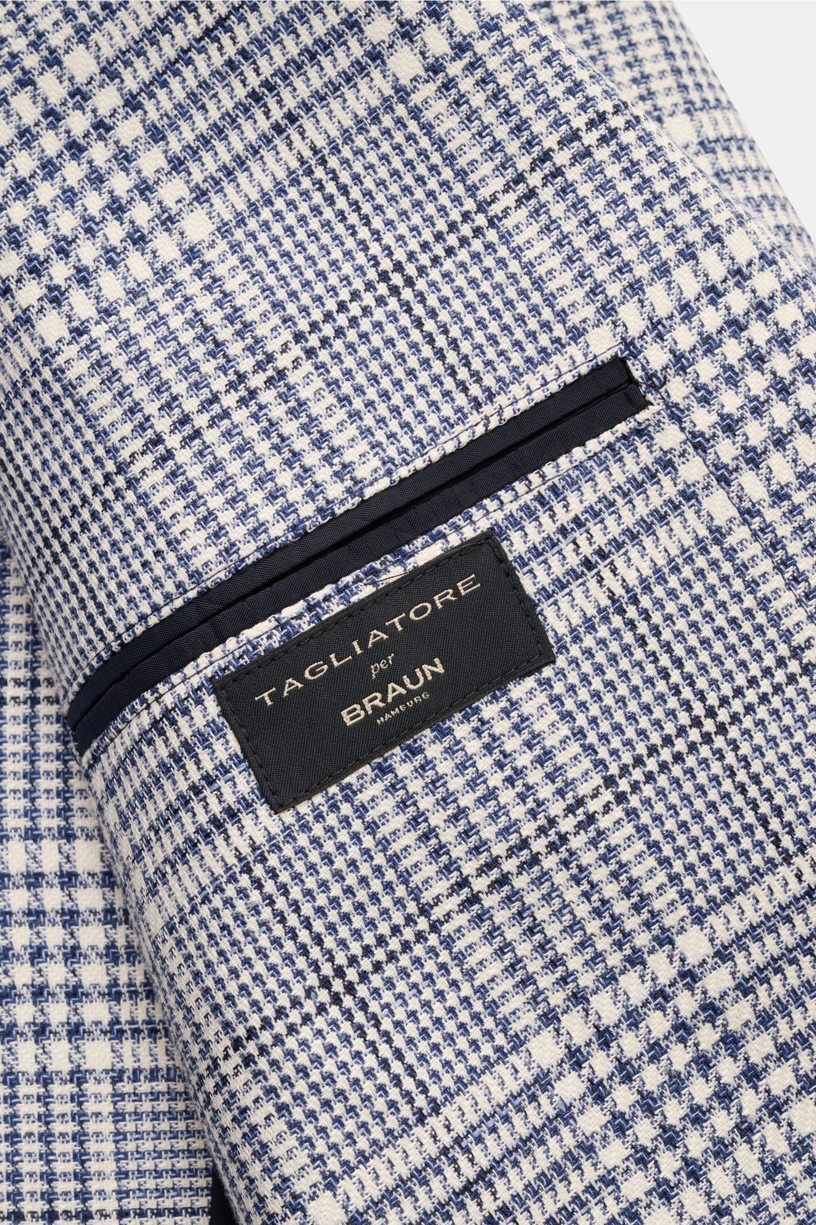 Close-up side view of Tagliatore Smart-casual jacket 'Monte Carlo' dark blue/cream checked sleeve with a black label on Glen check fabric.

