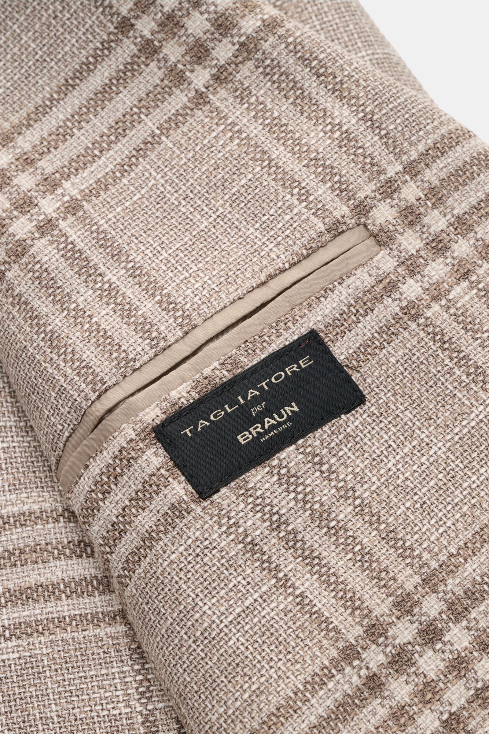 Close-up view of the fabric and label of the Tagliatore Smart-casual jacket 'Monte Carlo' beige/taupe checked showing textured, elasticated blend of virgin wool, cotton, and silk.

The unconstructed finish in a fine blend of fabrics and the elegant che