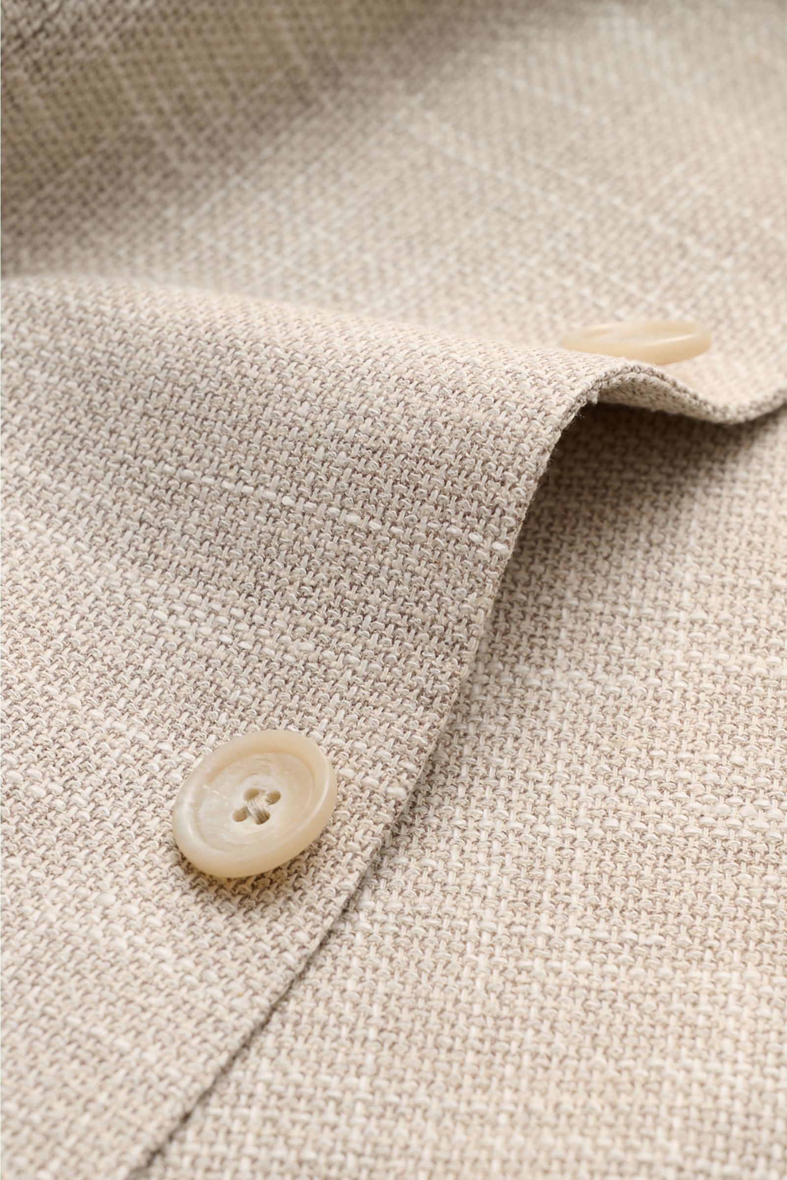 Close-up front detail of the beige mottled Tagliatore Smart-casual jacket 'Monte Carlo' showing textured fabric and buttons from a top angle. The unconstructed finish in a fine blend of fabrics refined by effect yarn for a relaxed weave makes the smart-ca