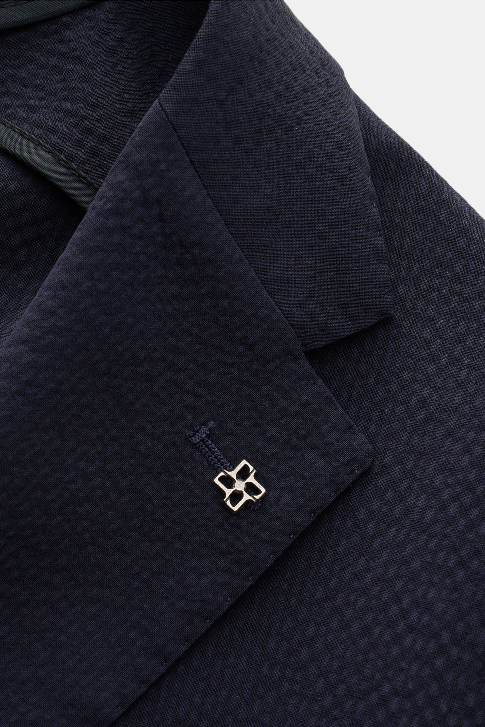 Close-up angled view of the lapel on the Tagliatore Smart-casual jacket 'Monte Carlo' navy, showcasing fine seersucker texture, signature pin, and lightweight Super 100s virgin wool fabric with slightly elasticated, unconstructed design.