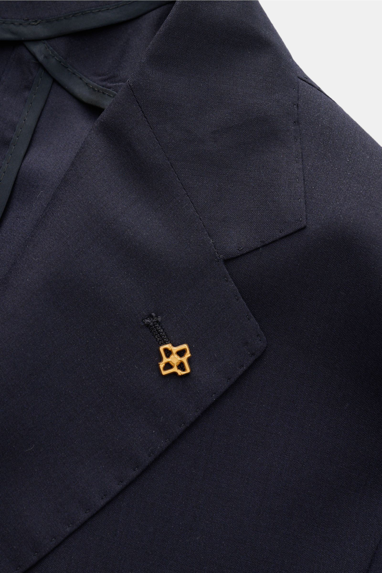 Close-up front angle of Tagliatore Smart-casual jacket 'Monte Carlo' navy lapel with gold signature pin, showcasing fabric texture.


