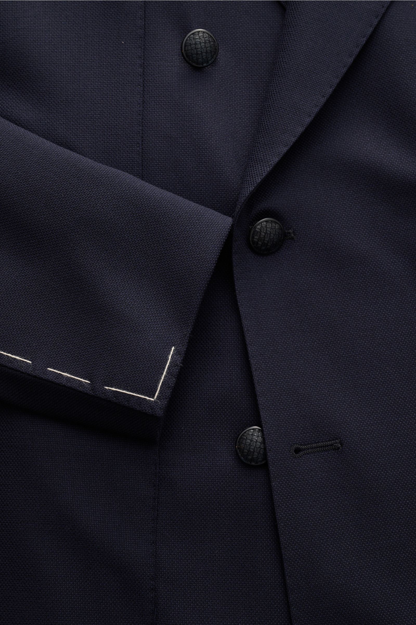 Nahaufnahme des Tagliatore Sakkos 'Monte Carlo' navy in Slim Fit aus elastischer Super 110'S Schurwolle, zweireihig mit drei schwarzen Knöpfen und Unconstructed Design, Blick auf Ärmel mit weißen Nähten.