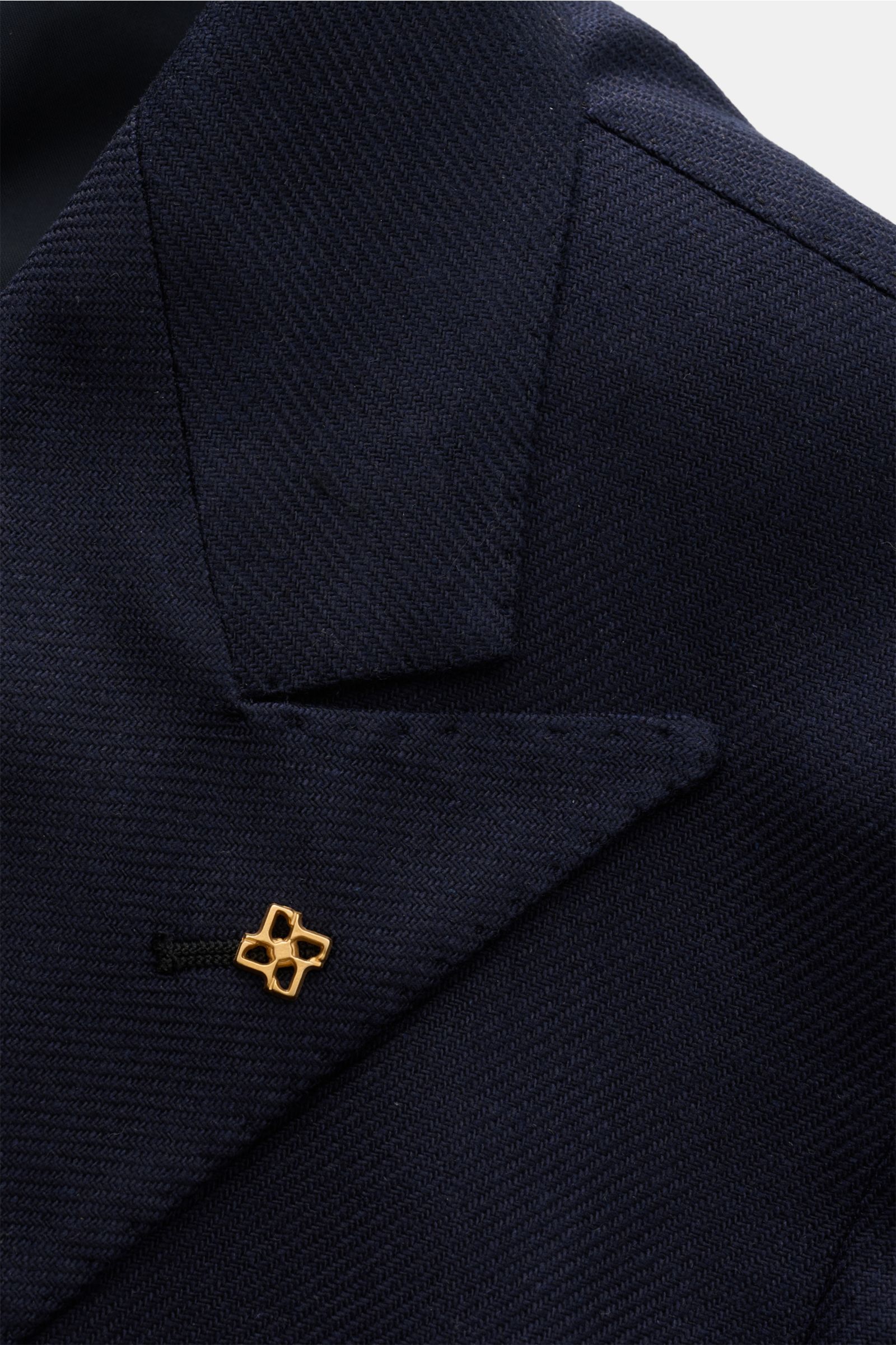 Nahaufnahme des spitz zulaufenden Revers vom Tagliatore Seidensakko 'Vesuvio' navy aus reiner Seide mit weichem Griff und markant strukturierter Webung, goldfarbener Pin am Revers sichtbar.
