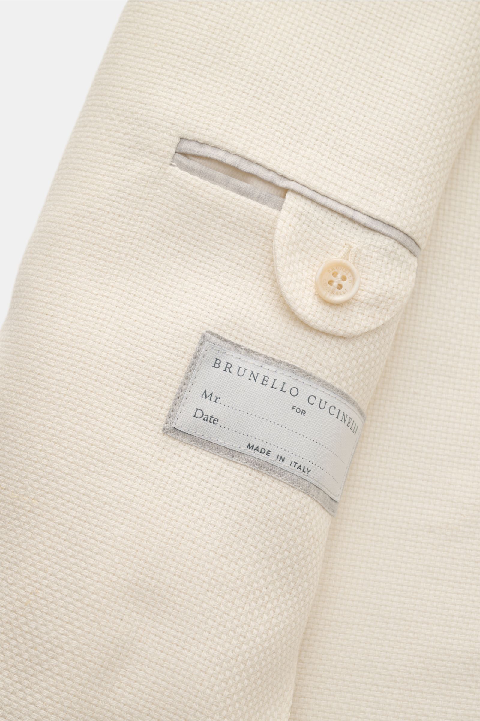 Brunello Cucinelli Sakko creme in Nahaufnahme von innen, zeigt halb gefütterte Innentasche, Knopf und feine Panama-Webstruktur.