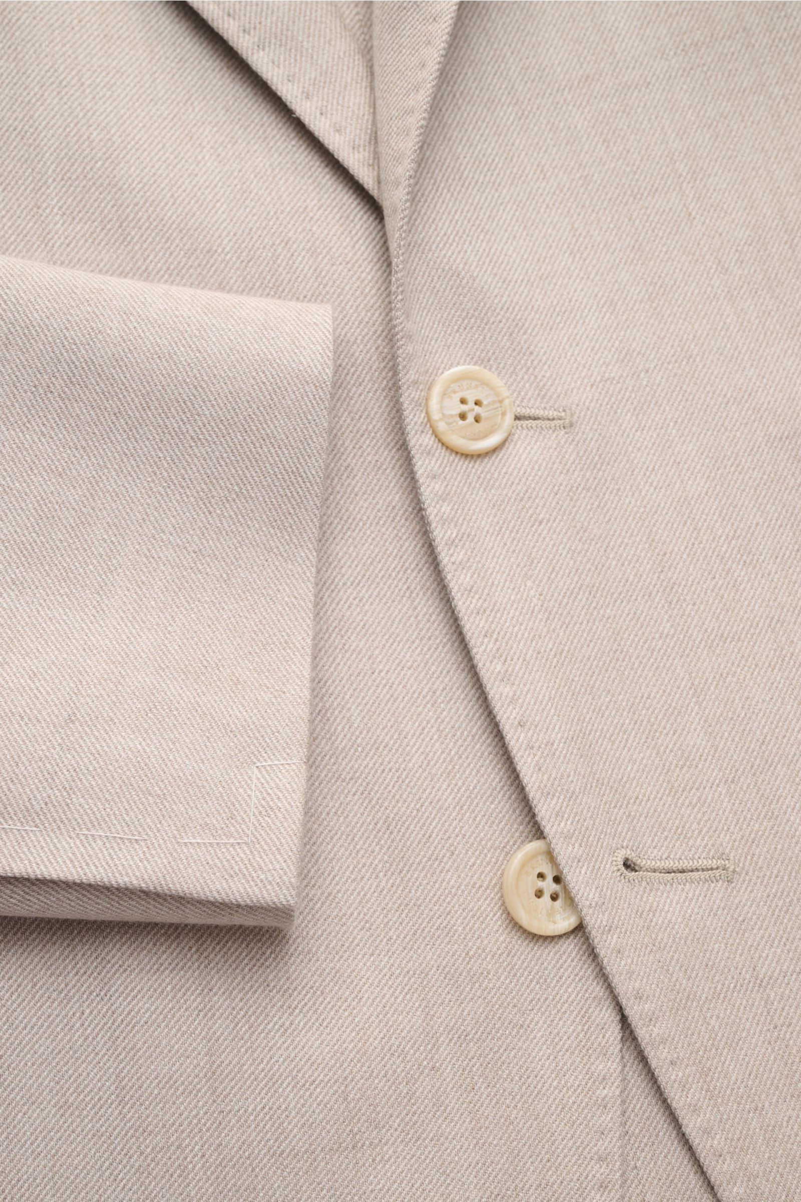 Brunello Cucinelli Sakko sand meliert, Nahaufnahme von Knöpfen, fallendem Revers, tailliertem Drei-Knopf-Stil, weichem Cashmere-Seide-Mix, markanter Webstruktur.