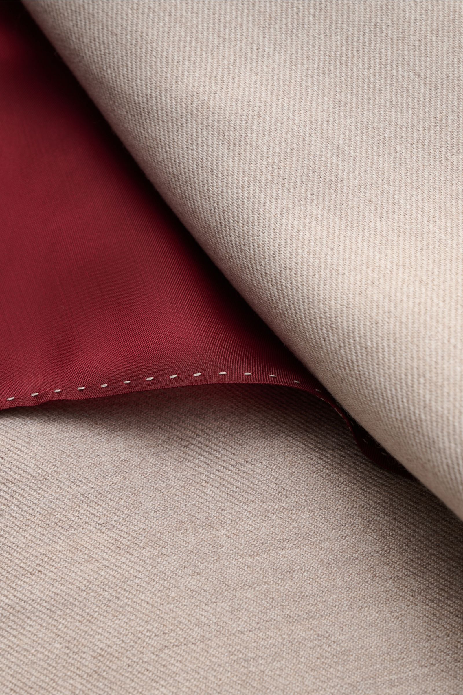Nahaufnahme des halb gefütterten Brunello Cucinelli Sakko sand meliert mit markanter Webstruktur und rotem Innenfutter.