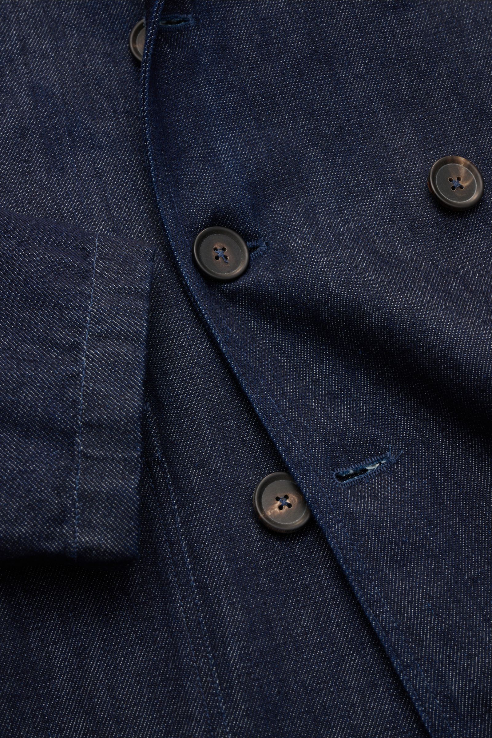 Close-up front view of the Doppiaa Denim jacket 'Aansonia' navy, showing its pure cotton denim fabric, slim fit, double-breasted three-button style, step lapel, patch hip pockets, and unconstructed design, a new casual interpretation of a classic for urba