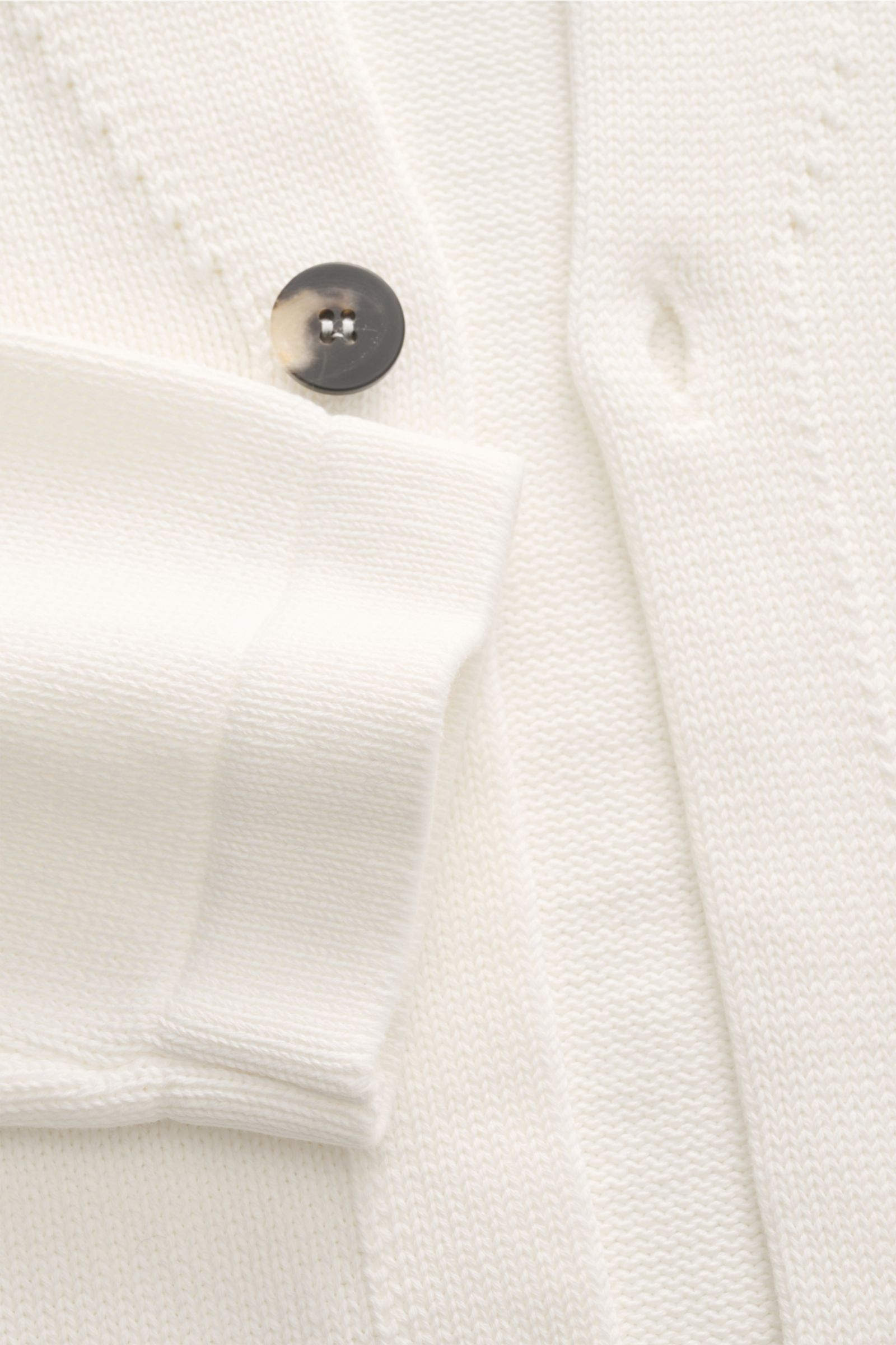 Close-up front view of the off-white Doppiaa Cardigan 'Aalviero' showing medium-fine cotton knit, two-button placket, knit standing collar, classic breast pocket, and patch hip pockets, highlighting timeless elegance for the transitional season with a reg