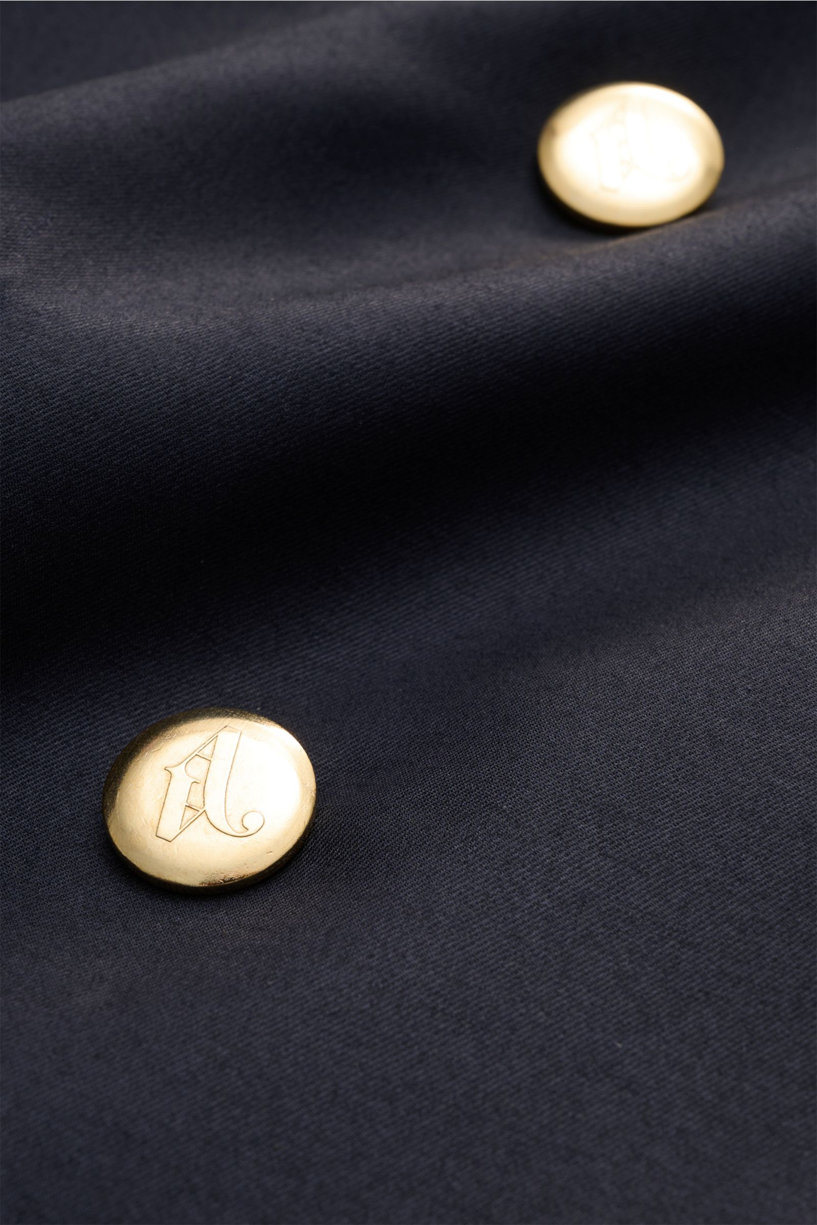 Nahaufnahme des navyfarbenen Doppiaa Sakko 'Aanversa' mit goldfarbenen Knöpfen aus Wolle-Seide-Twill und dezentem Glanz.