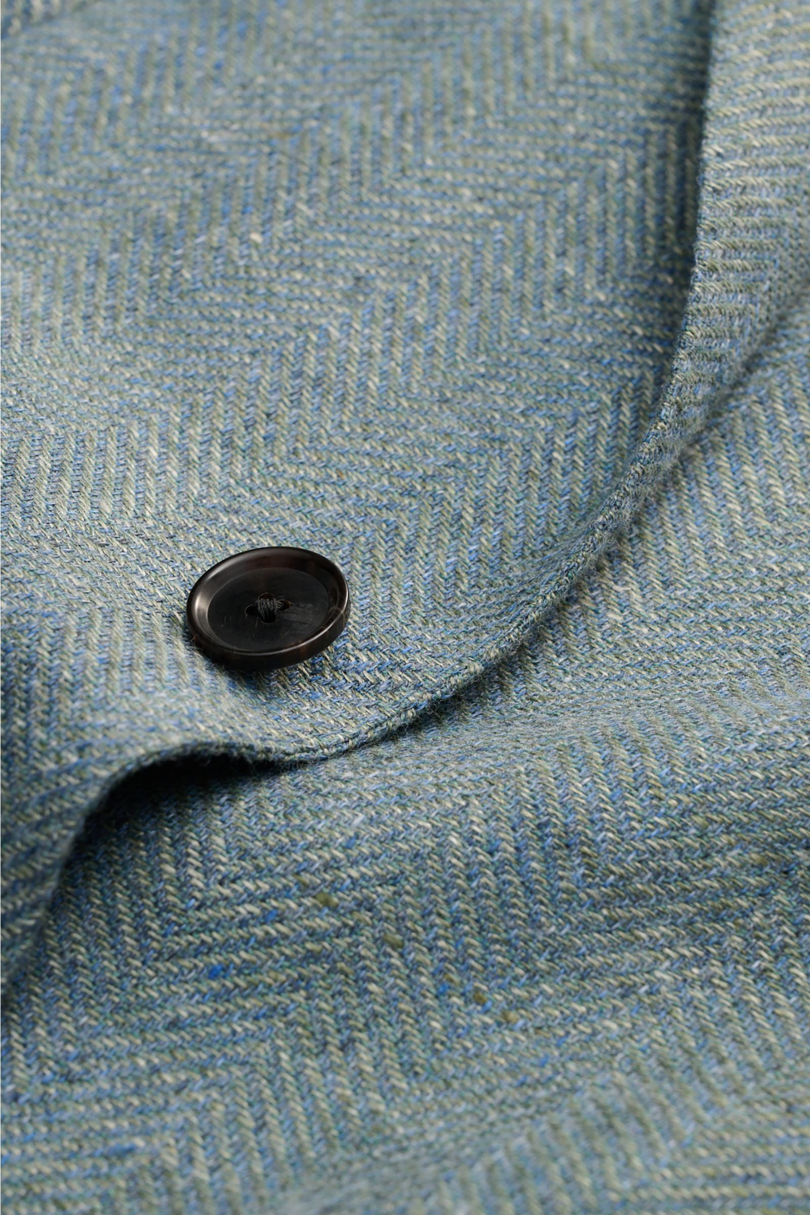 Close-up front detail of Caruso Smart-casual jacket 'Aida' grey-green mottled showing distinctive herringbone texture and button.

In the smart-casual jacket 'Aida', CARUSO combines smart style with fabric in the natural materials linen and wool – and 