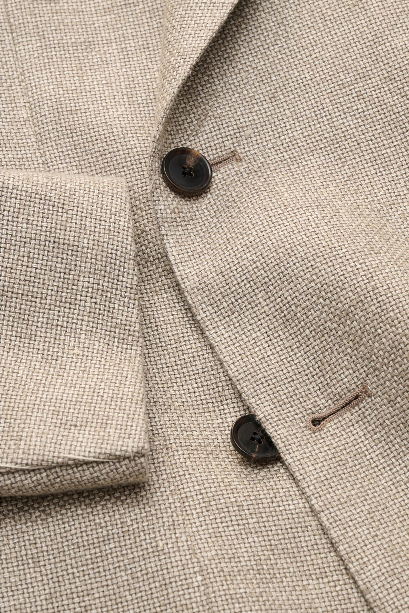 Nahaufnahme des Caruso Sakko 'Aida' beige meliert im rustikalen italienischen Stil mit markanter Hanf-Woll-Webstruktur, steigendem Spitzrevers und zwei braunen Knöpfen, fotografiert von oben.