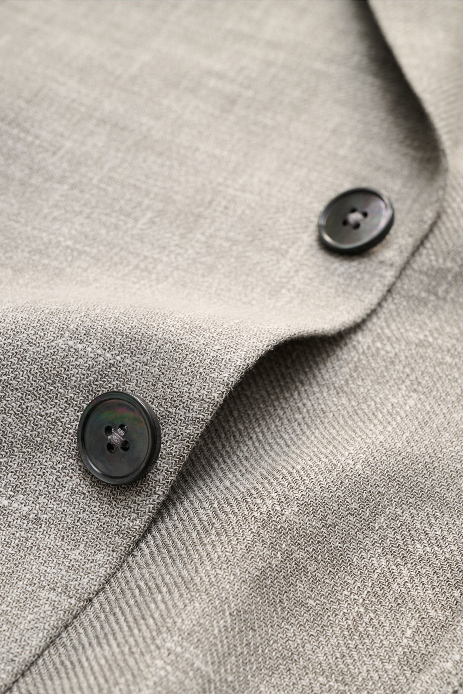 Close-up front-side view of Zegna Smart-casual jacket 'Riviera' grey/white mottled showing fine weave linen-wool-silk blend fabric and black buttons.

The smart-casual jacket 'Riviera' by ZEGNA made of linen and wool with silk content has a comfortably