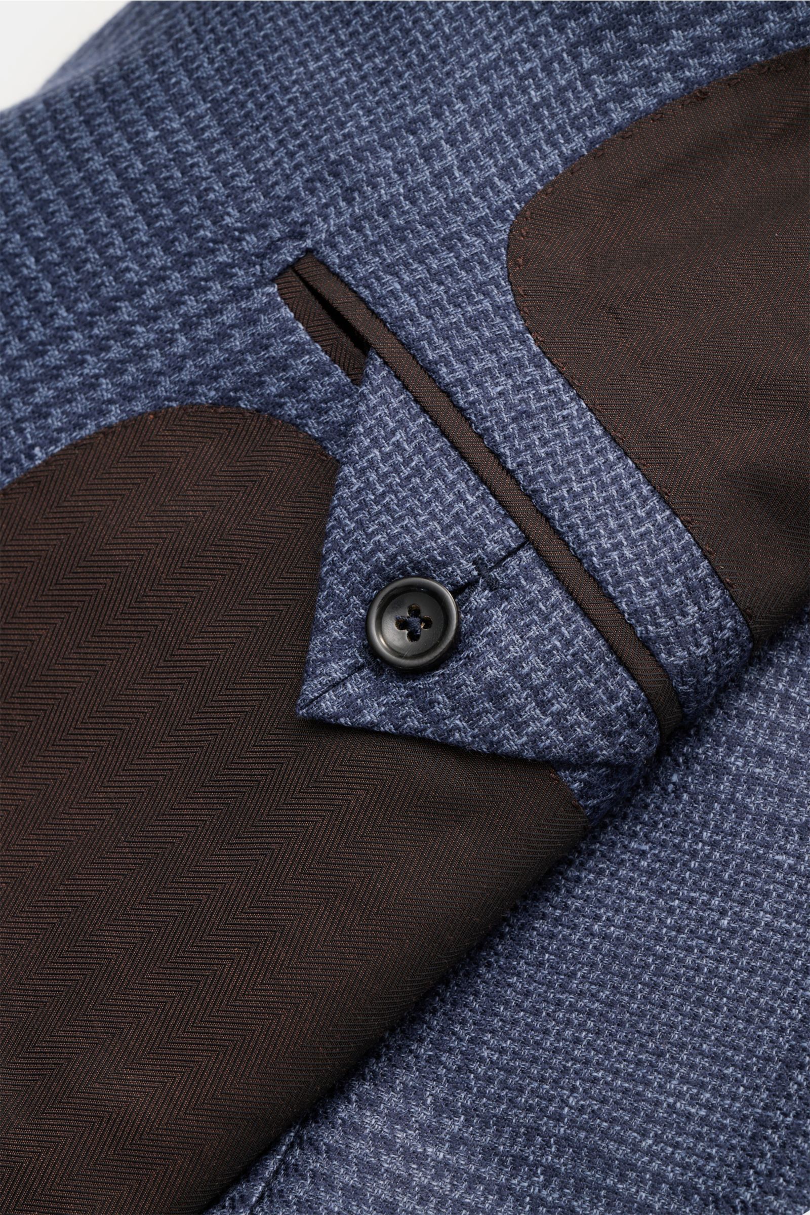 Nahaufnahme aus schräger Perspektive des Zegna Sakko 'Atelier' navy/rauchblau kariert mit Glencheck-Karo, Knopf, Brusttasche und Ellbogen-Patch.