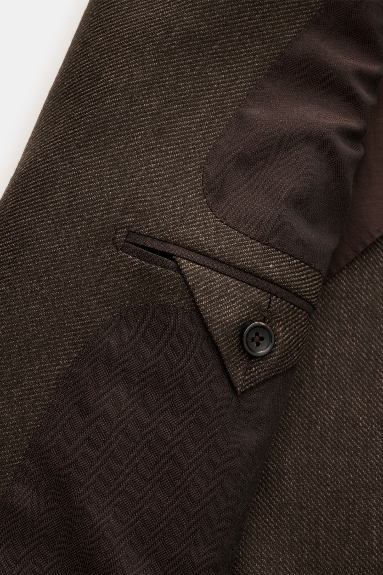 Nahaufnahme des Zegna Sakko dunkelbraun von innen und Ärmel mit feinem Webmuster, weicher Griff, Slim Fit, zwei Knöpfen, halb gefüttert.