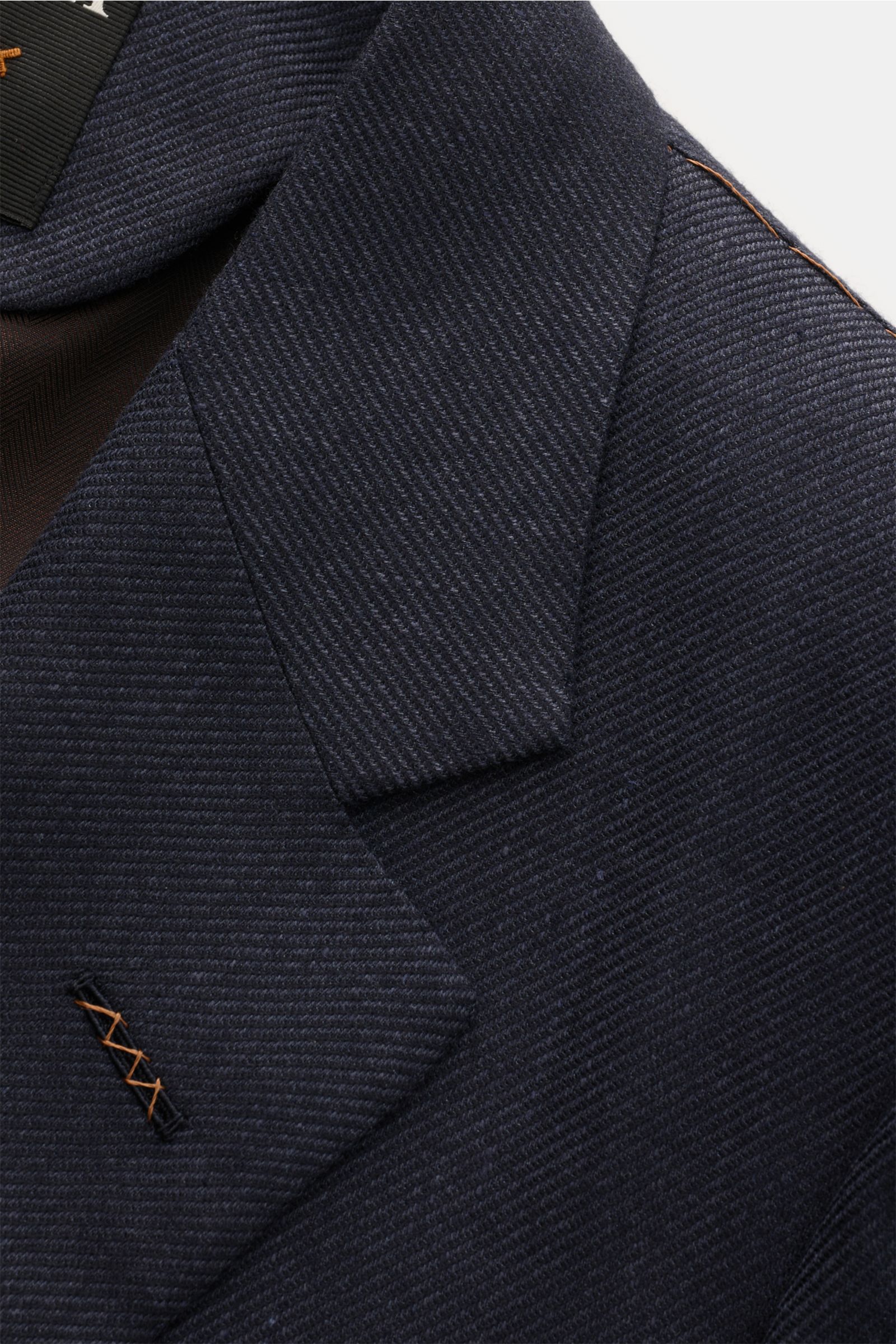 Nahaufnahme des Zegna Sakko dark navy mit feinem Webmuster, fallendem Revers und weichem Griff aus Cashmere, Seide und Leinen.