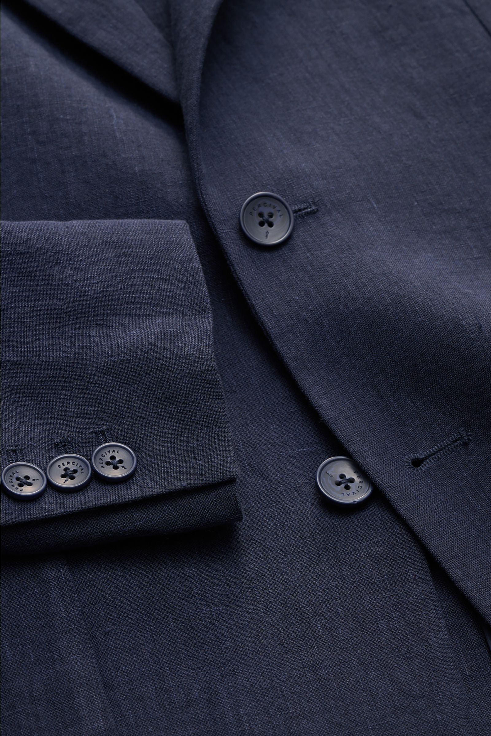 Percival Sakko 'Tailored Linen' navy aus Leinen-Baumwoll-Mix, Slim Fit, fallendes Revers, Knöpfe an Ärmelabschlüssen, Brust- und Hüfttaschen, halb gefüttert, Detailaufnahme von vorne schräg oben.