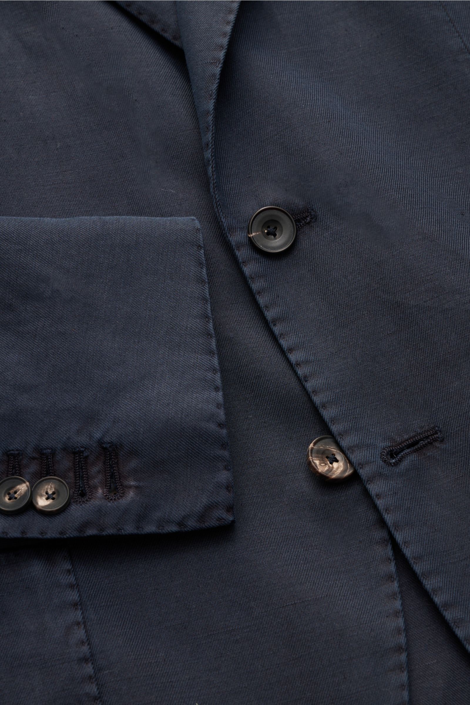 Close-up front view of Santaniello Smart-casual jacket navy showing button, lapel, and cuff details in cotton, linen, mohair blend.

Modern tailoring for the transitional period: This smart-casual jacket by SANTANIELLO enhances numerous spring looks wi