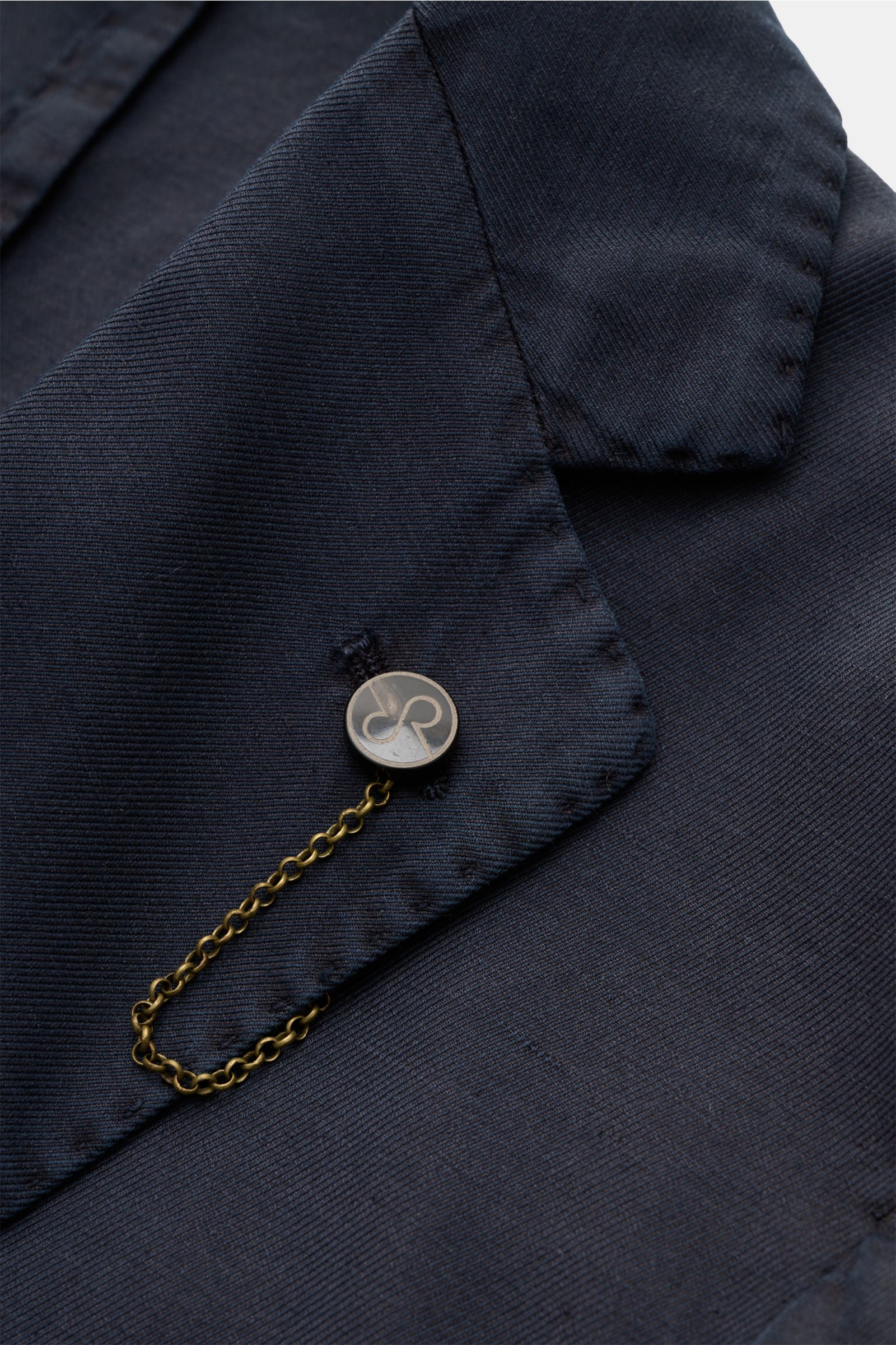 Close-up front view of the collar and label pin on the Santaniello Smart-casual jacket navy, showcasing its soft cotton, linen, and mohair blend with a slim fit and unconstructed design.

Modern tailoring for the transitional period: This smart-casual 