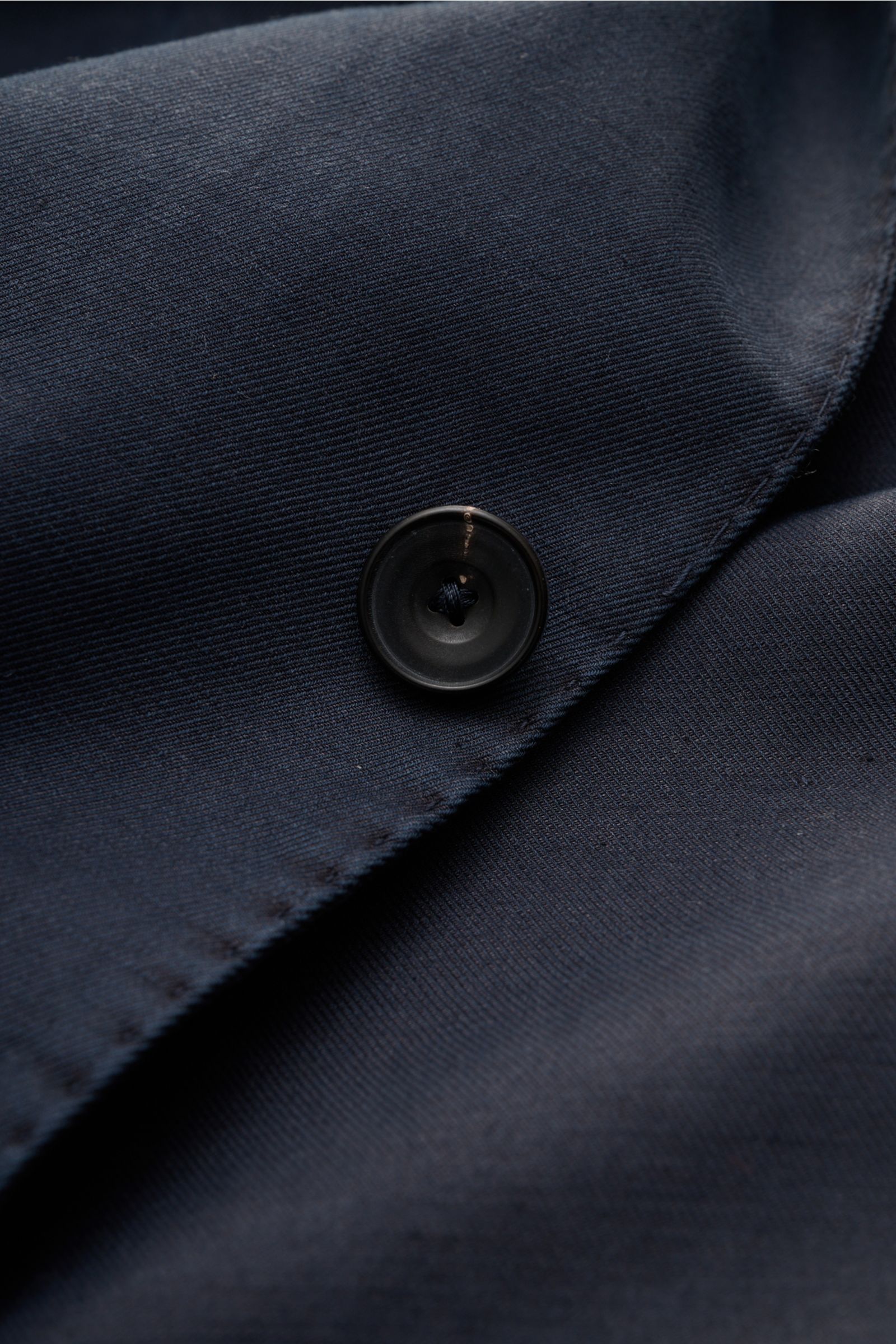 Close-up front view of the Santaniello Smart-casual jacket navy showing its button and fine fabric texture.

Description: Modern tailoring for the transitional period: This smart-casual jacket by SANTANIELLO enhances numerous spring looks with its rela