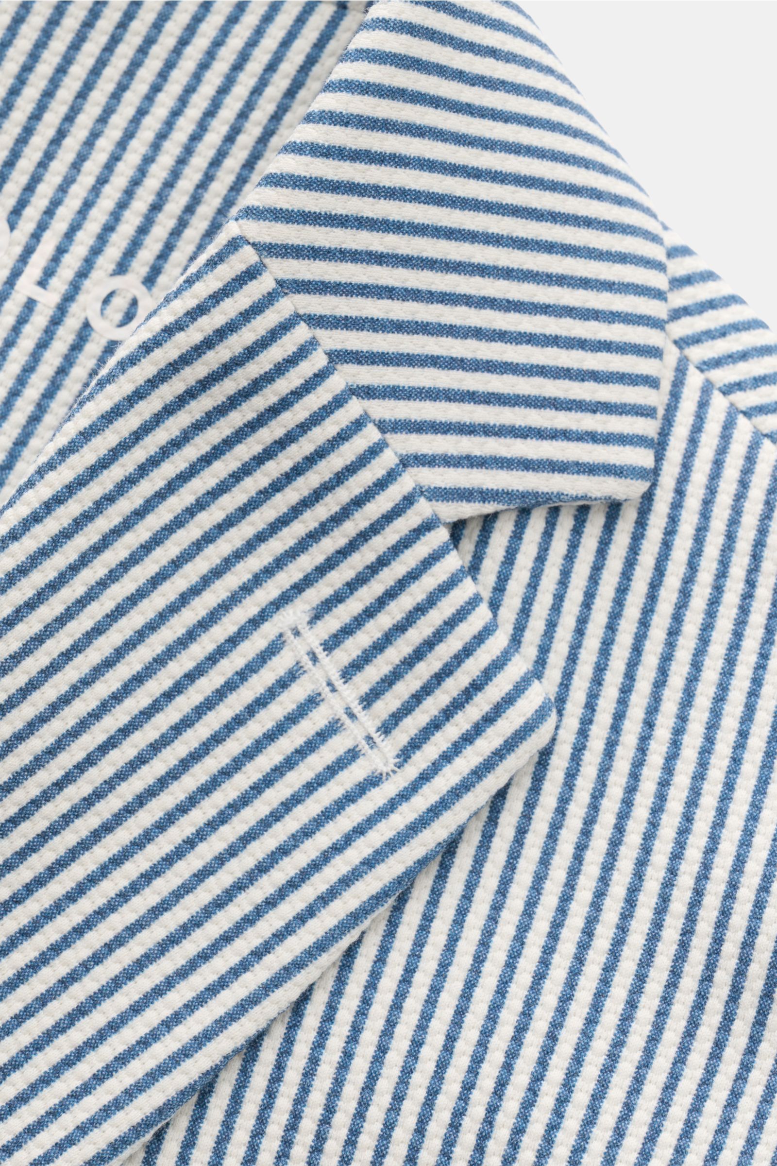 Nahaufnahme des Circolo 1901 Jersey-Sakkos weiß/blau gestreift von schräg oben, zeigt leicht griffigen Jersey in sommerlicher Seersucker-Optik mit klassischem Streifenmuster, fallendem Revers und Ärmelabschluss mit Knopf.