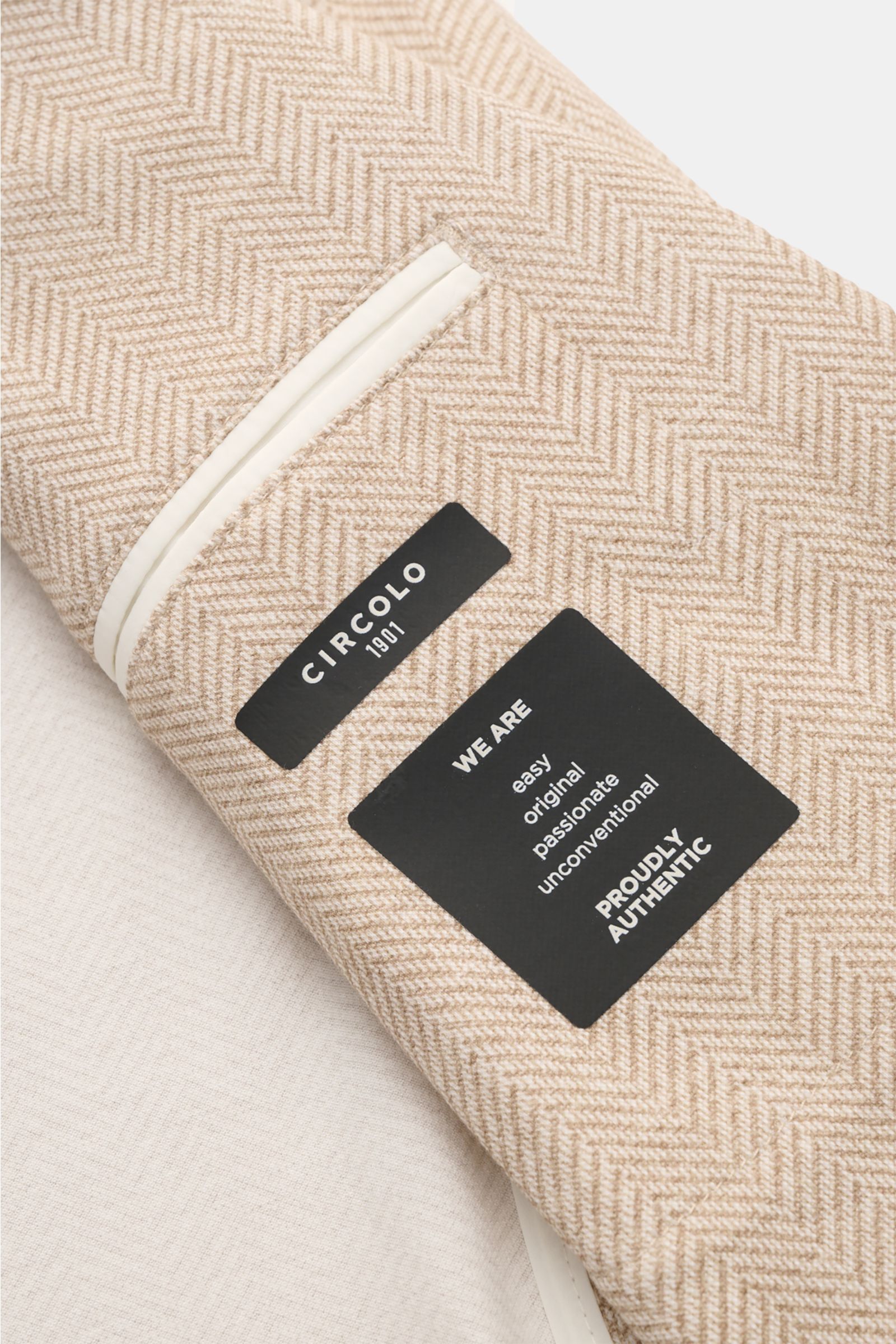 Close-up top-down view of the Circolo 1901 Jersey jacket beige/cream patterned showing detailed herringbone fabric and interior pocket trim.

Casual elegance for warm days: This smart-casual jacket with herringbone pattern by CIRCOLO 1901 is made of li