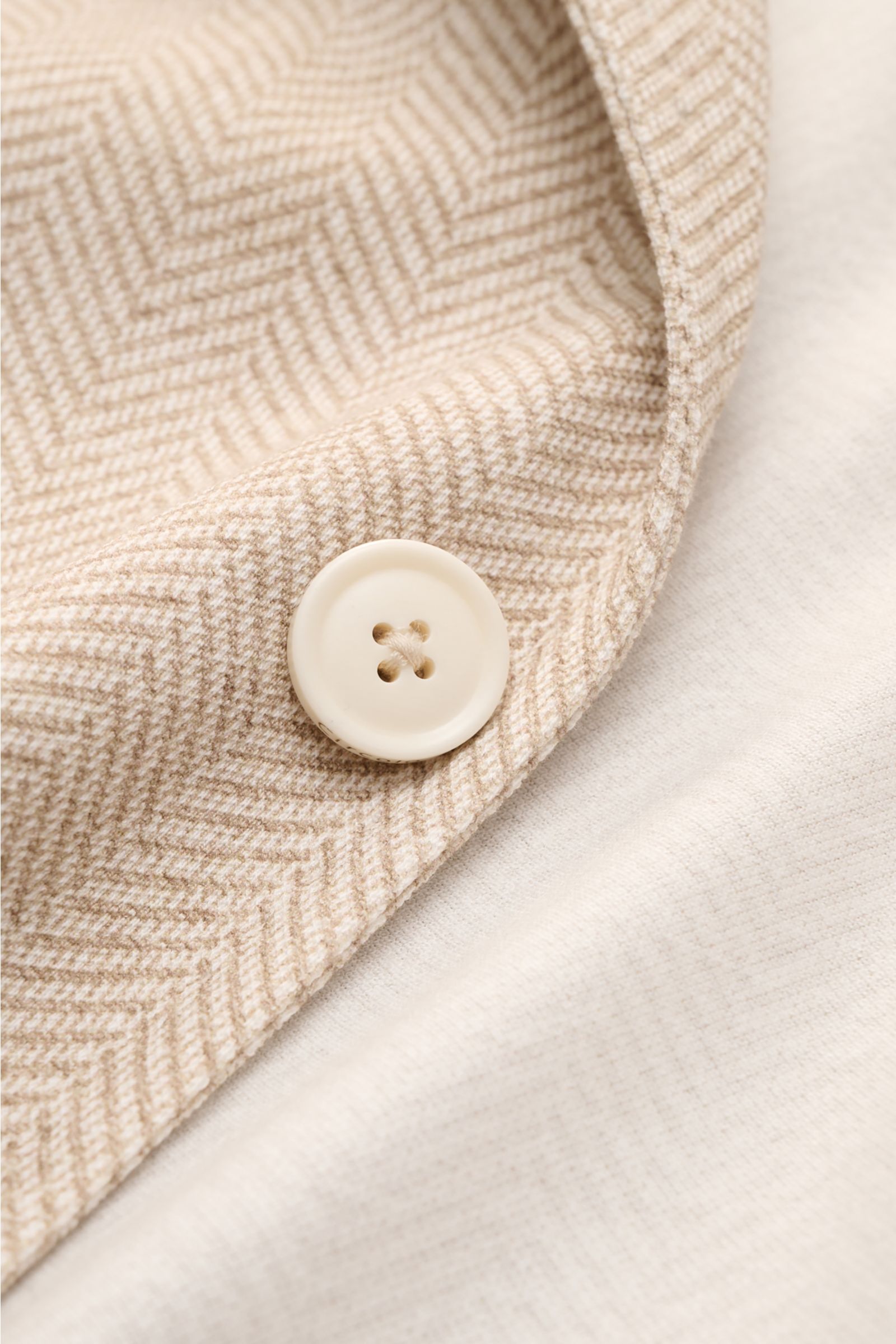 Close-up front view of the Circolo 1901 Jersey jacket beige/cream patterned showing the herringbone fabric and a cream button.

Casual elegance for warm days: This smart-casual jacket with herringbone pattern by CIRCOLO 1901 is made of lightweight jers