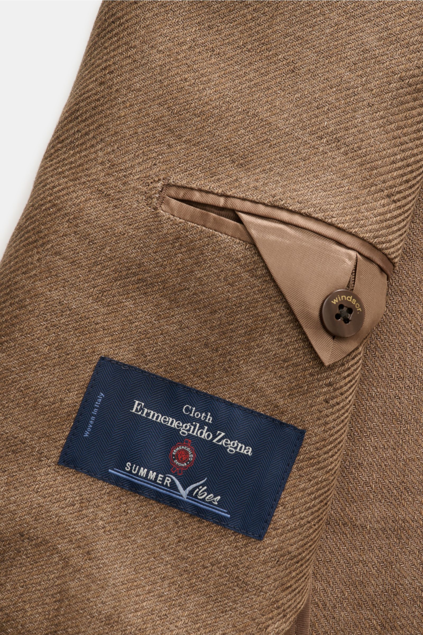 Close-up of the inner pocket and button detail of the Windsor Smart-casual jacket 'Giorno' brown mottled, photographed from an angled top-down view. British elegance with summery lightness: The 'Giorno' unconstructed smart-casual jacket by WINDSOR, crafte