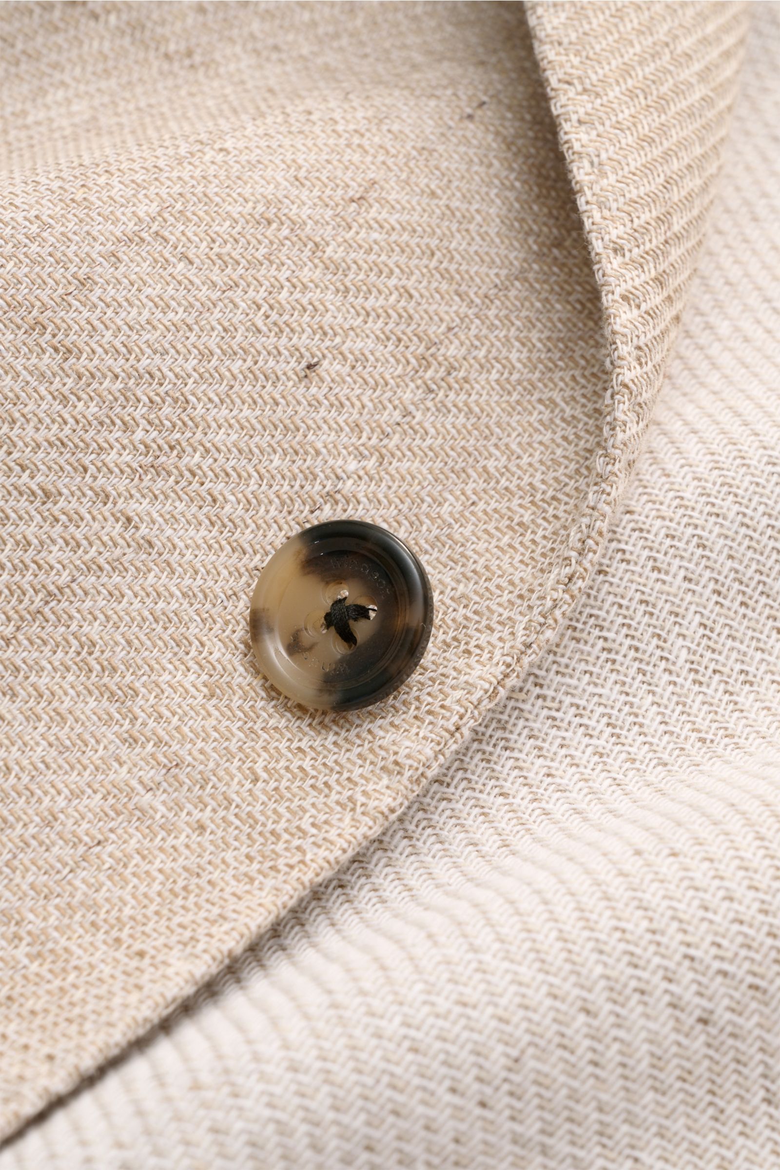 Close-up detail of the beige mottled fabric and horn button on the Windsor Smart-casual jacket 'Giorno,' photographed from above to highlight texture and stitching.

Stylish and uncomplicated: With the lightweight, unconstructed 'Giorno' smart-casual j