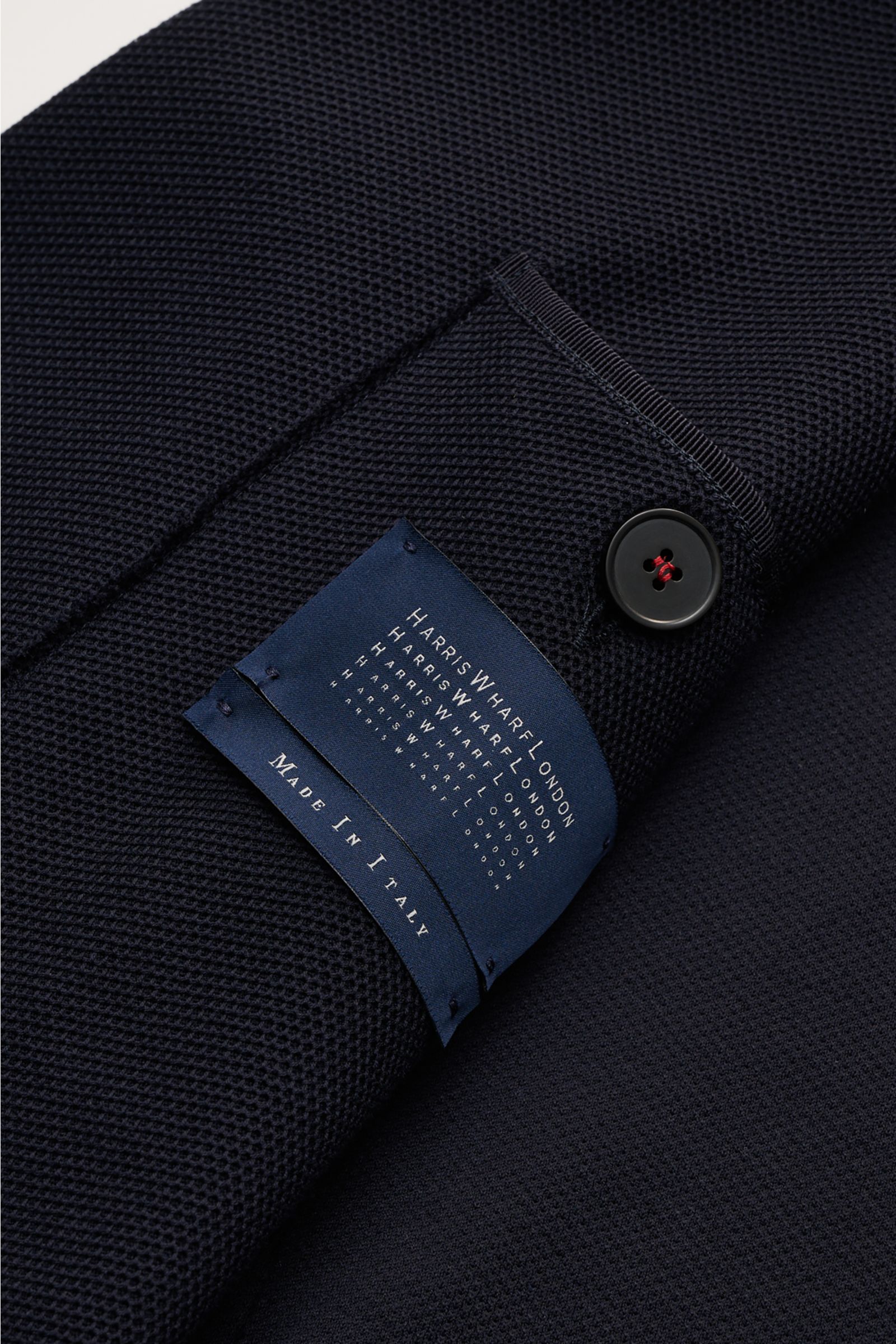 Close-up top view of Harris Wharf London Blazer navy sleeve showing waffle texture, button, and label made in Italy.

Lightweight blazer from HARRIS WHARF: This model with a fine but distinctive waffle texture is made of fine Loro Piana cotton and is a