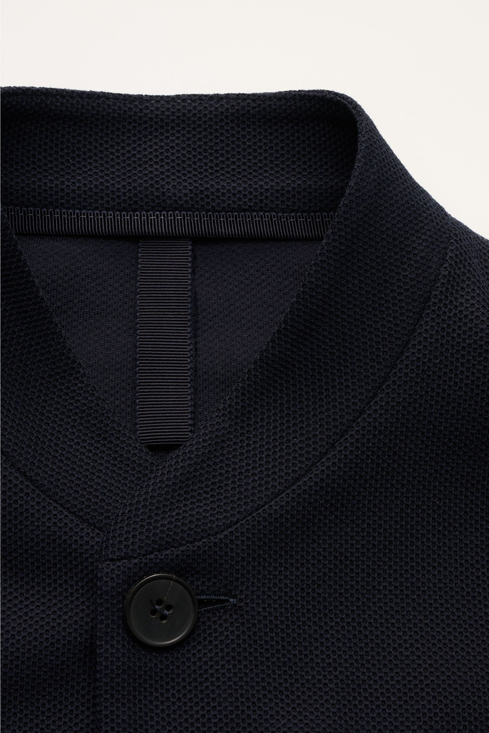 Close-up front view of Harris Wharf London Knit blazer navy showing slim standing collar, button, and textured pure piqué cotton fabric. 

Description: HARRIS WHARF LONDON has chosen a high-quality cloth from Loro Piana for this relaxed knit blazer. Pu