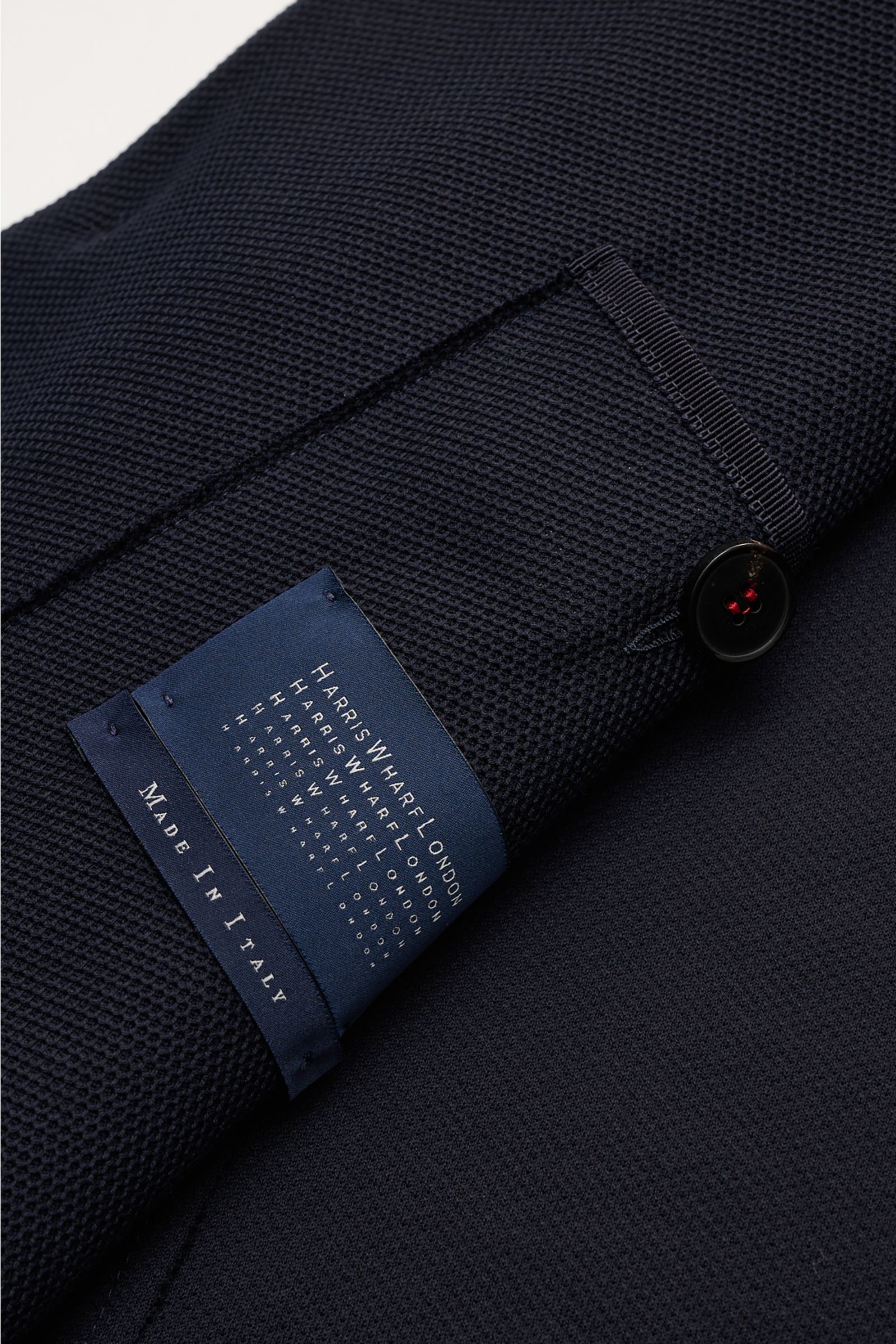 Close-up angled view of the Harris Wharf London Knit blazer navy showing navy pure piqué cotton fabric, button, and label.

HARRIS WHARF LONDON has chosen a high-quality cloth from Loro Piana for this relaxed knit blazer. Pure cotton piqué meets a dist