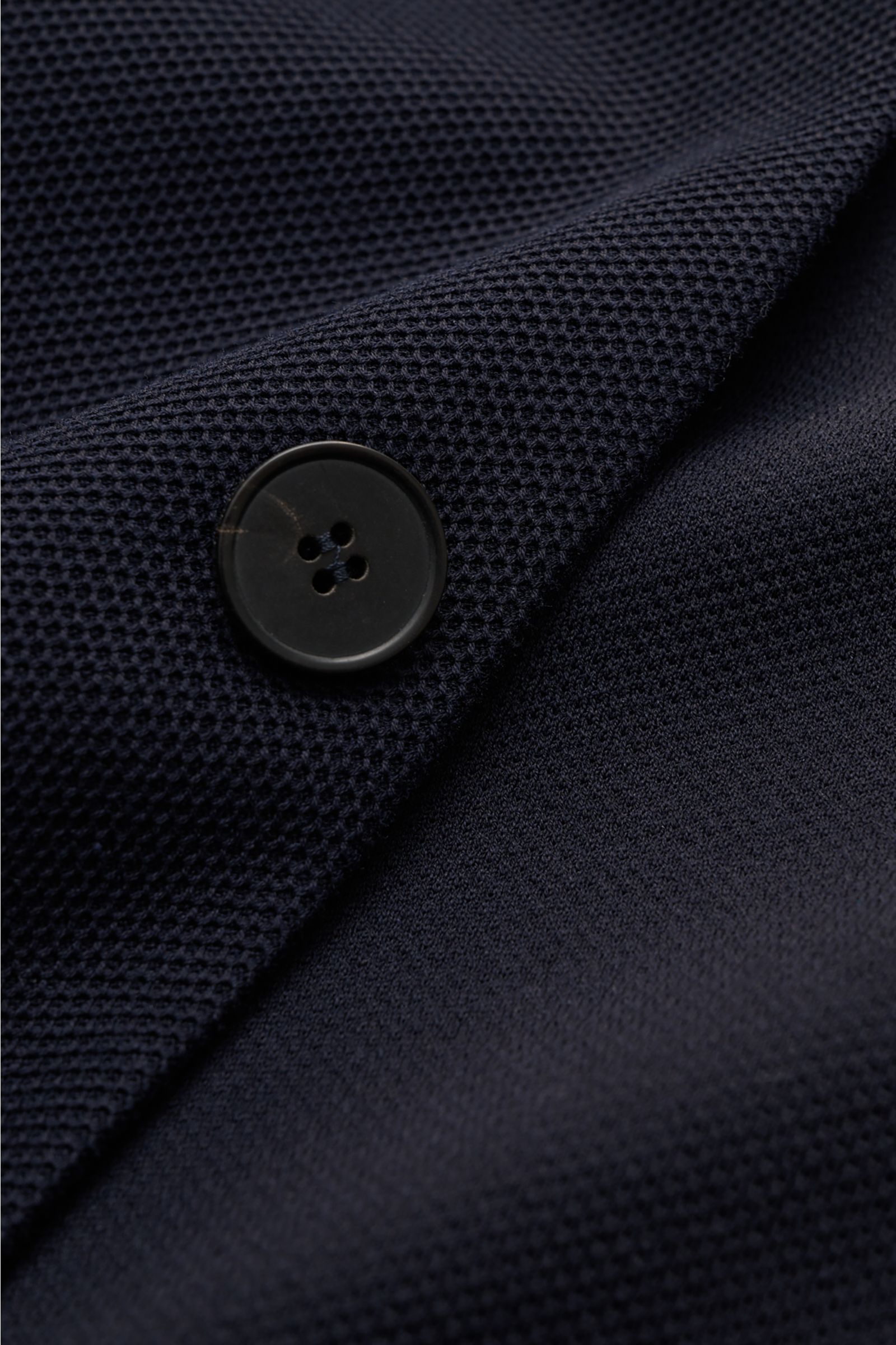 Close-up front view of Harris Wharf London Knit blazer navy showing navy pure piqué cotton fabric, black four-hole button, and textured knit.

HARRIS WHARF LONDON has chosen a high-quality cloth from Loro Piana for this relaxed knit blazer. Pure cotton