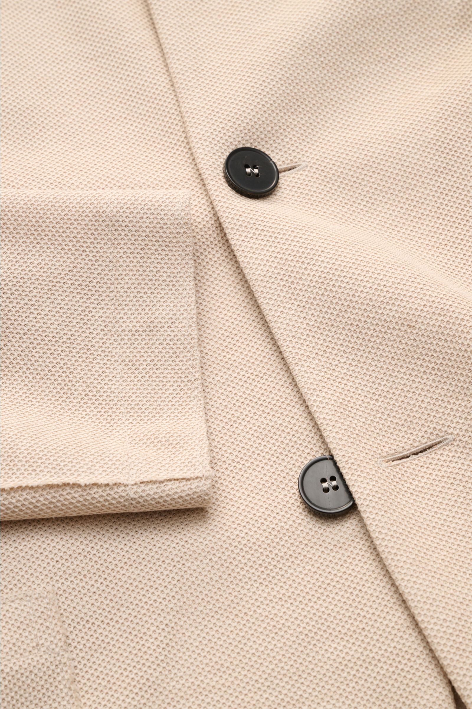 Close-up top view of Harris Wharf London Knit blazer beige showing pure piqué cotton fabric, black buttons, and patch pocket detail. 

Description: HARRIS WHARF LONDON has chosen a high-quality cloth from Loro Piana for this relaxed knit blazer. Pure c
