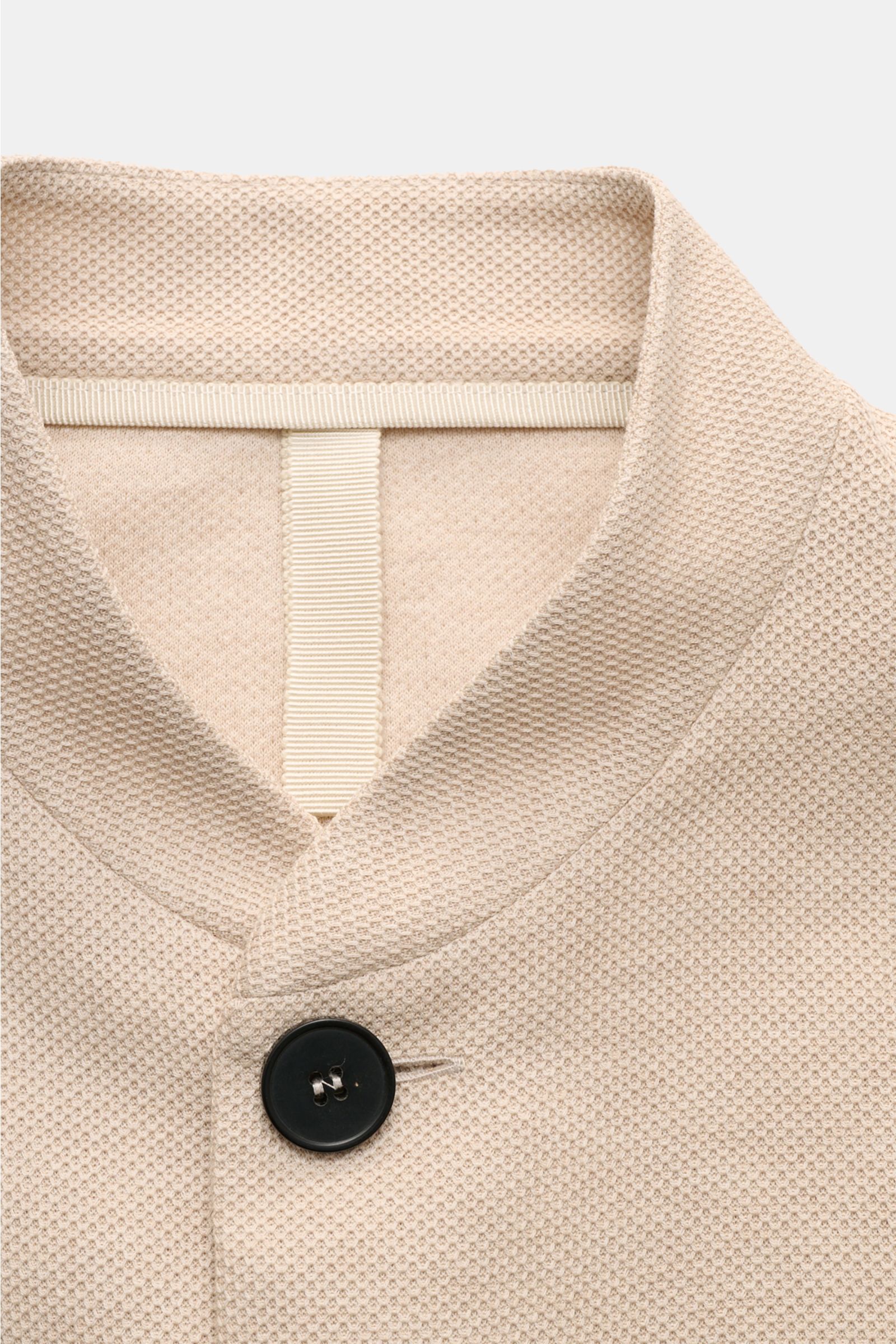 Harris Wharf London Knit blazer beige shown from a close-up front perspective, highlighting pure piqué cotton, open edge finish, and a black button detail. 

HARRIS WHARF LONDON has chosen a high-quality cloth from Loro Piana for this relaxed knit blaz