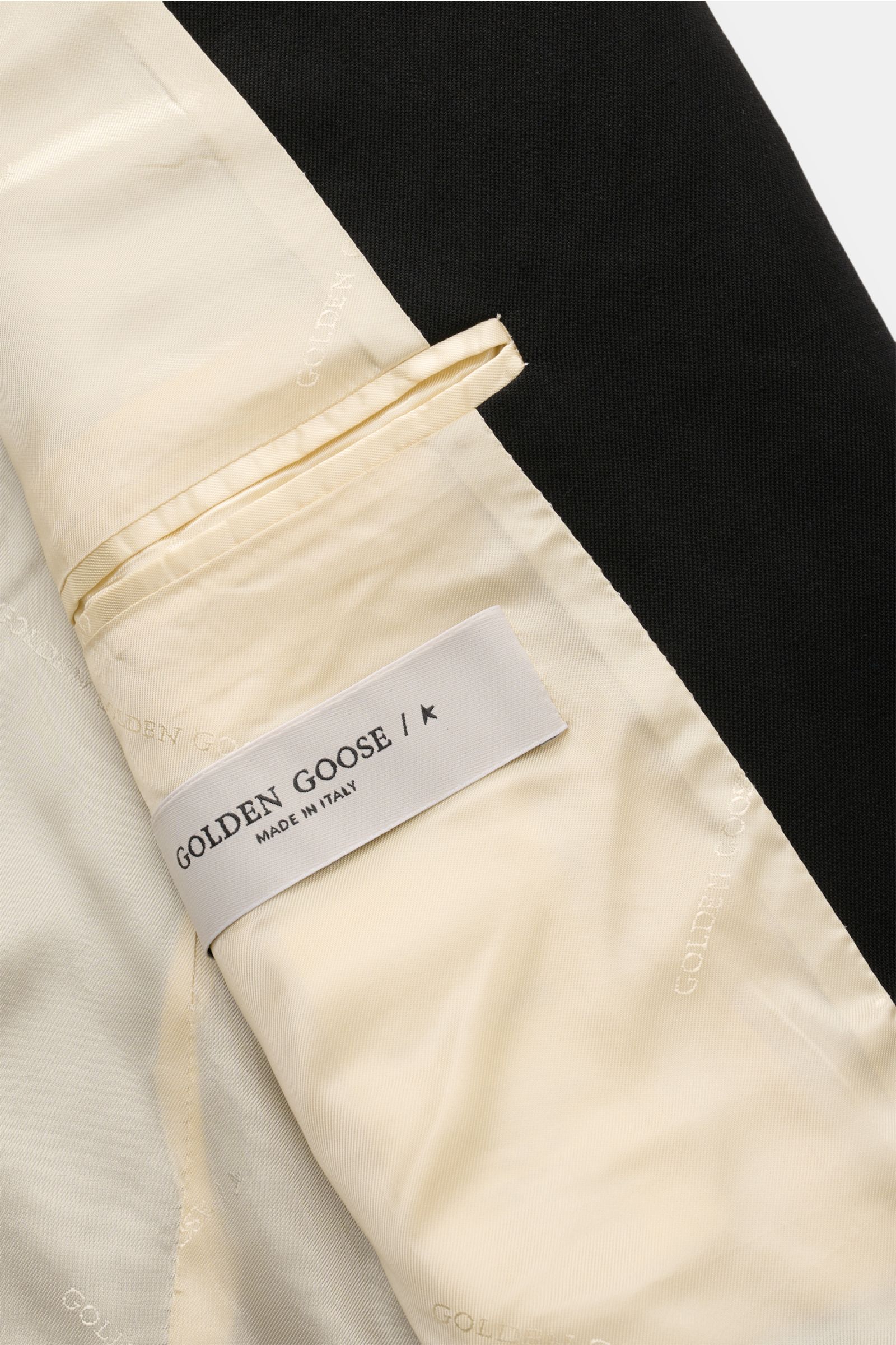 Nahaufnahme des Innenfutters des Golden Goose Sakko 'Dave' schwarz, mit gebrandetem cremefarbenem Futter und Label „Made in Italy“.