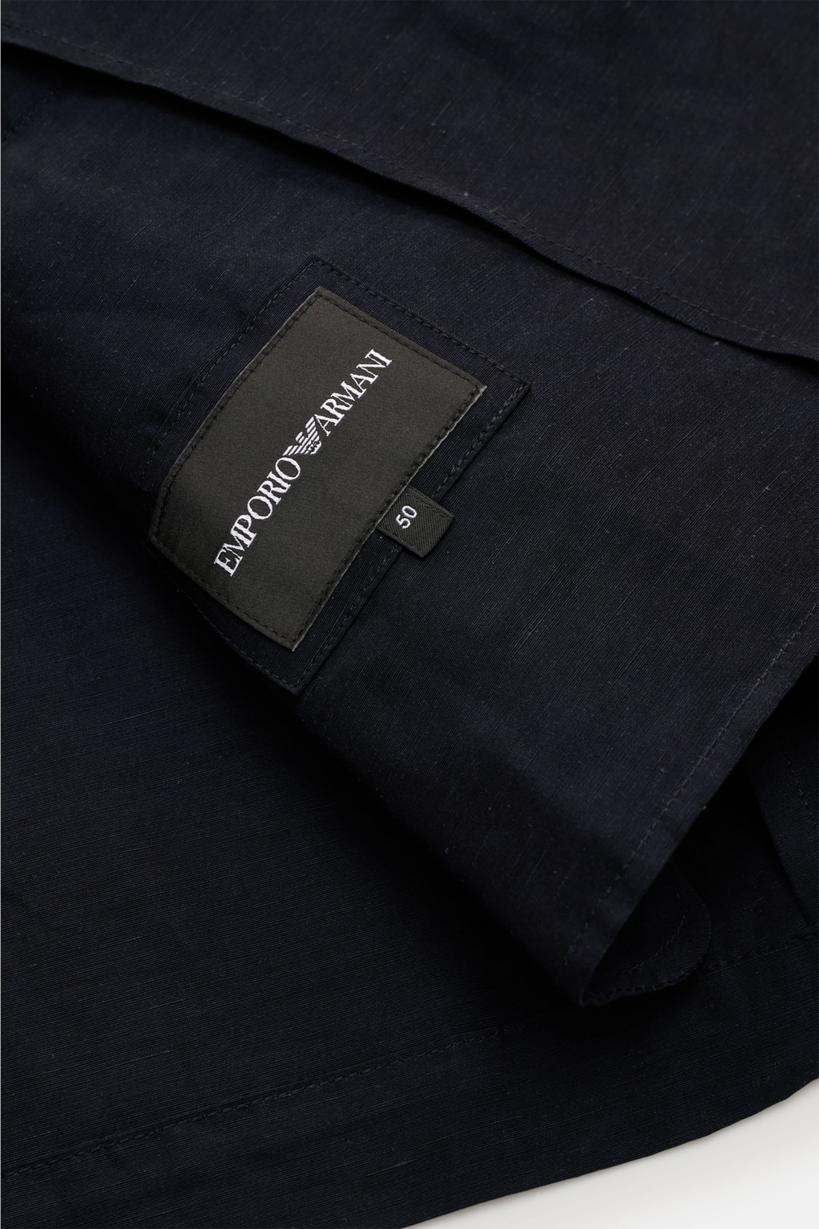Nahaufnahme des Emporio Armani Sakko dark navy aus Viskose-Leinen-Mix mit feiner Struktur, leichtem Materialglanz und Innenetikett.