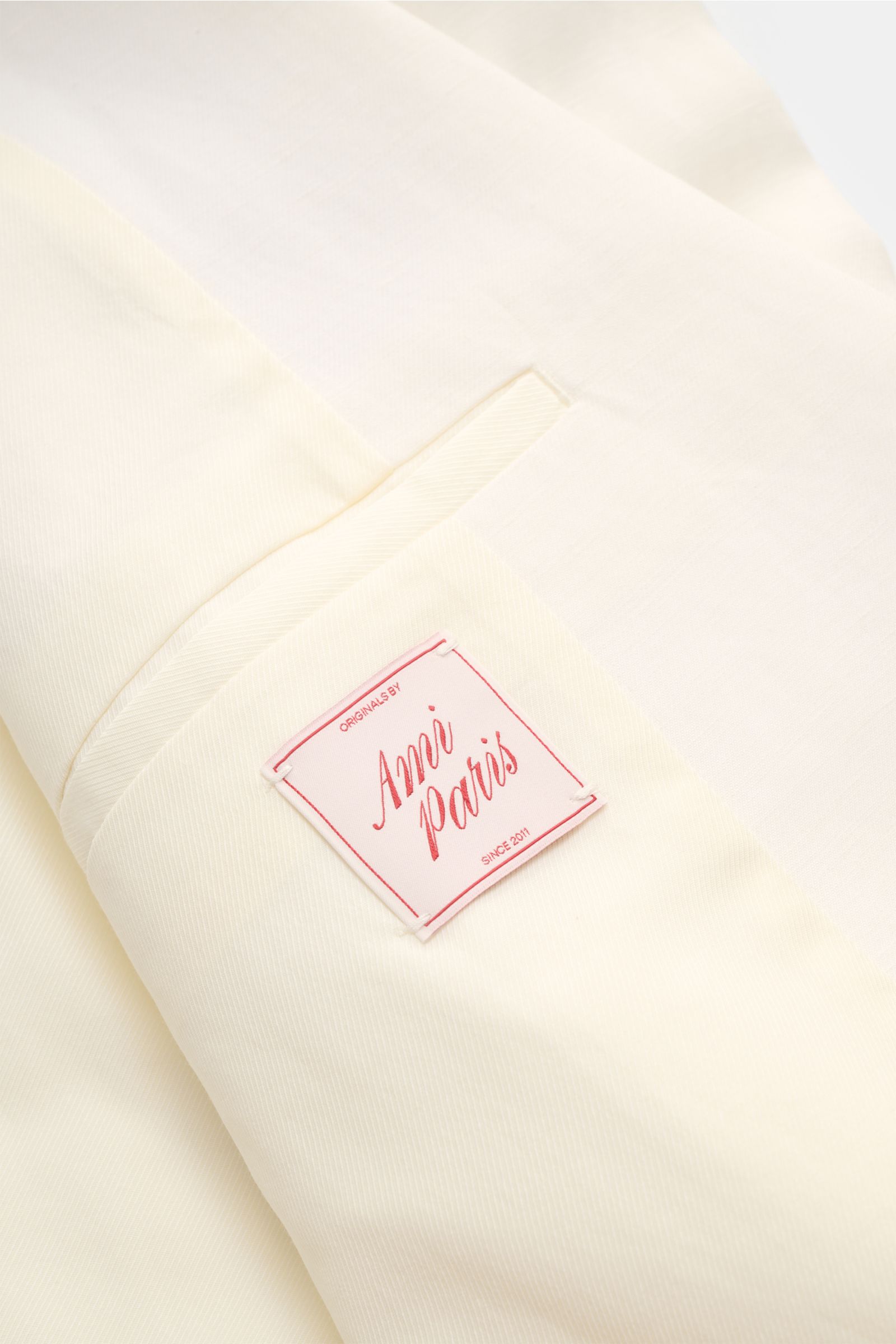 Nahaufnahme des cremefarbenen Ami Paris Sakko Innenbereichs mit Label, weichem Futter und feiner Viskose-Leinen-Mischung.