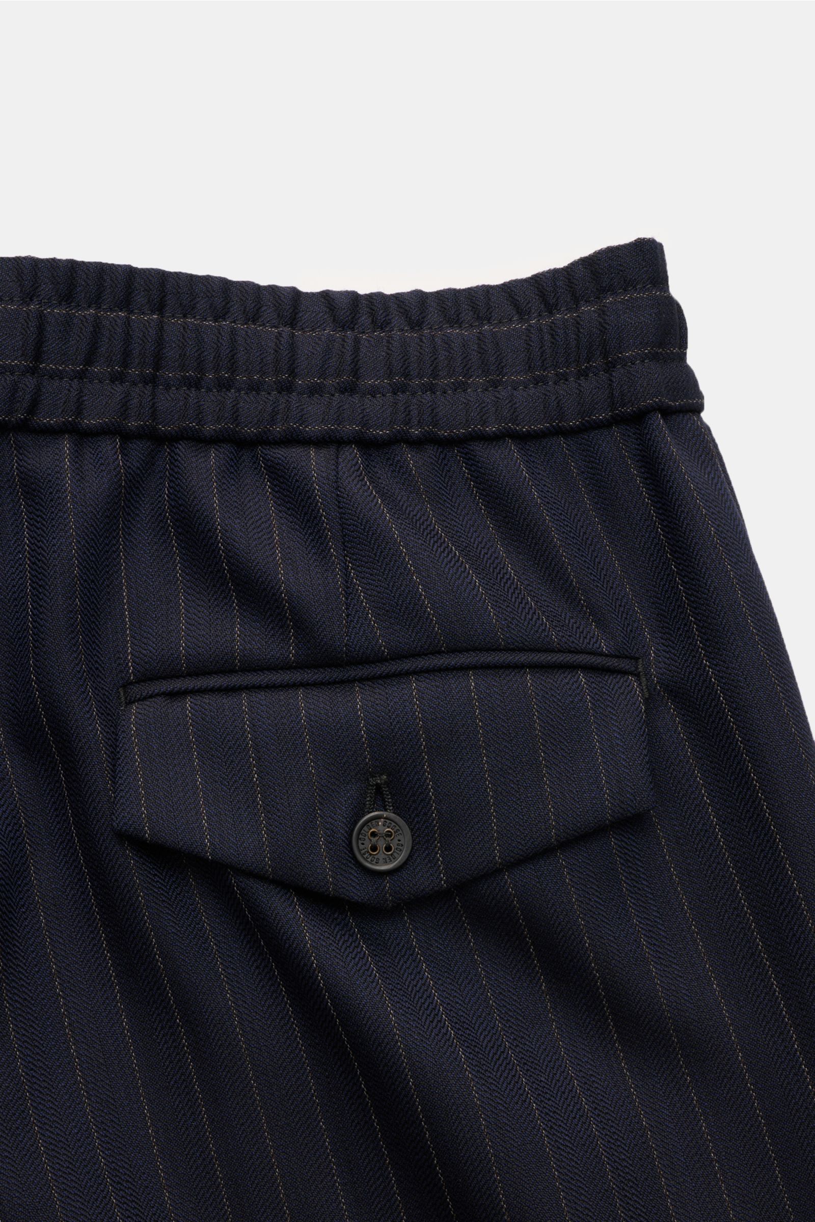 Nahaufnahme der rückwärtigen Gesäßtasche mit geknöpfter Patte der Golden Goose Woll-Jogpants navy/beige gestreift aus elastischer Schurwolle.