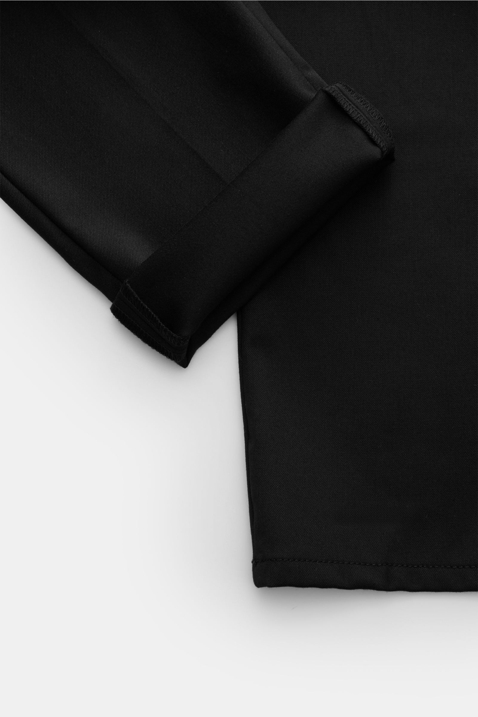 Nahaufnahme der Dondup Hose 'Gaubert' schwarz, Slim Fit mit schmal geschnittener Wade, weichem Griff, französischen Taschen, Metall-Initial, Reißverschluss, Slide Button, aus Microfaser, Wolle und Viskose, leicht elastisch, fotografiert von unten.