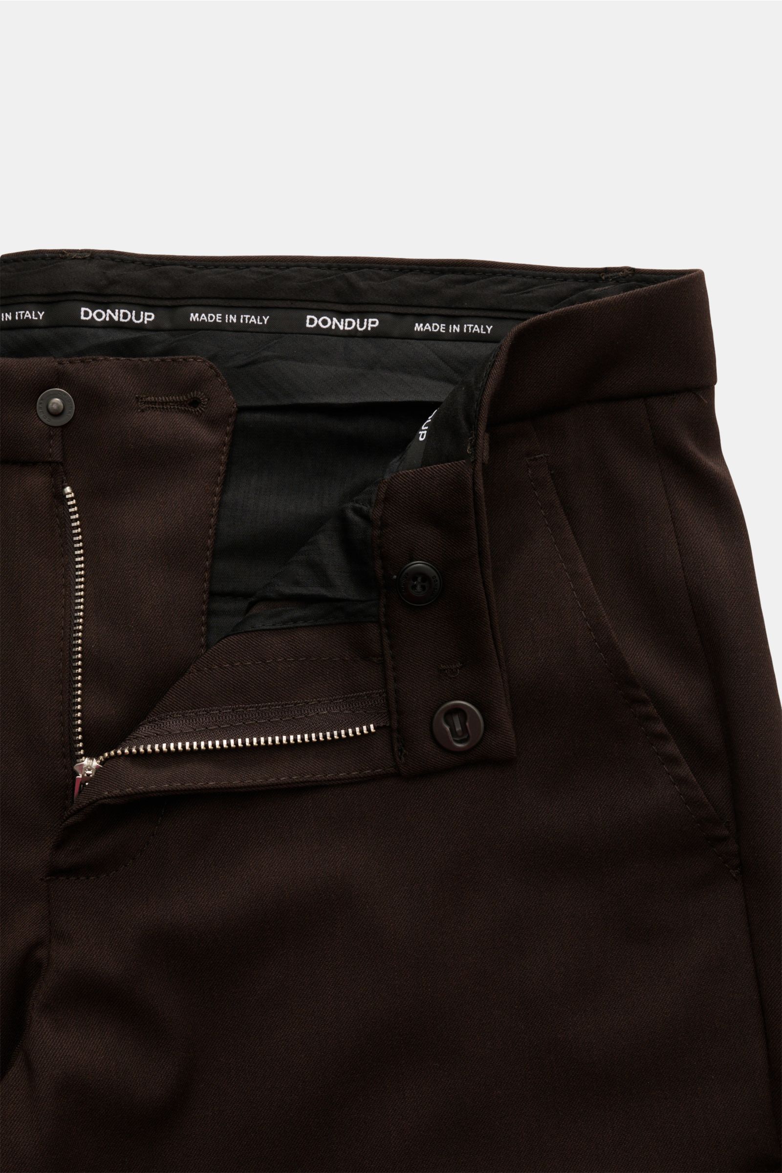 Close-up front view of Dondup Hose 'Gaubert' dunkelbraun trousers showing zipper, slide button, and French pockets, made of a microfiber, wool, and viscose blend with a soft feel, slim fit, narrow calves, back buttoned pockets, and typical metal initial.