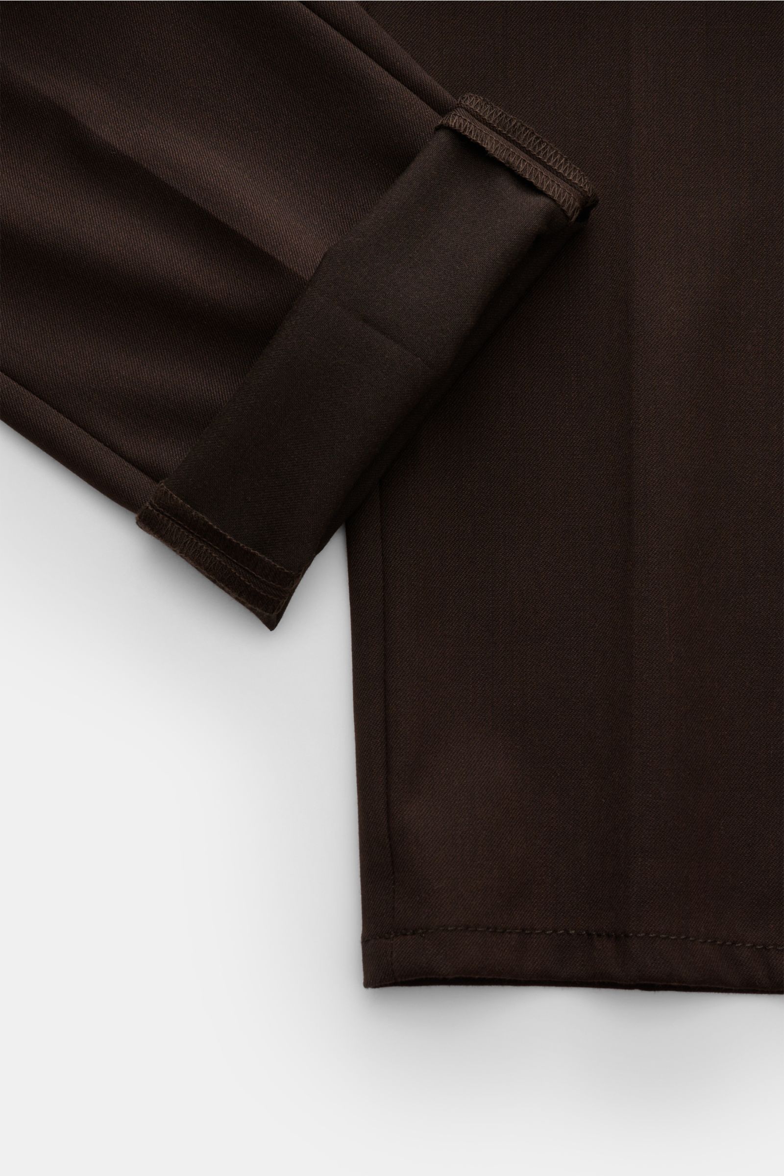 Close-up view of the Dondup Hose 'Gaubert' dunkelbraun fabric and hem, showing mix of microfiber, wool, viscose, soft touch, slim fit, narrow calf, zipper, slide button, French pockets, back pockets with button, and typical metal initial.