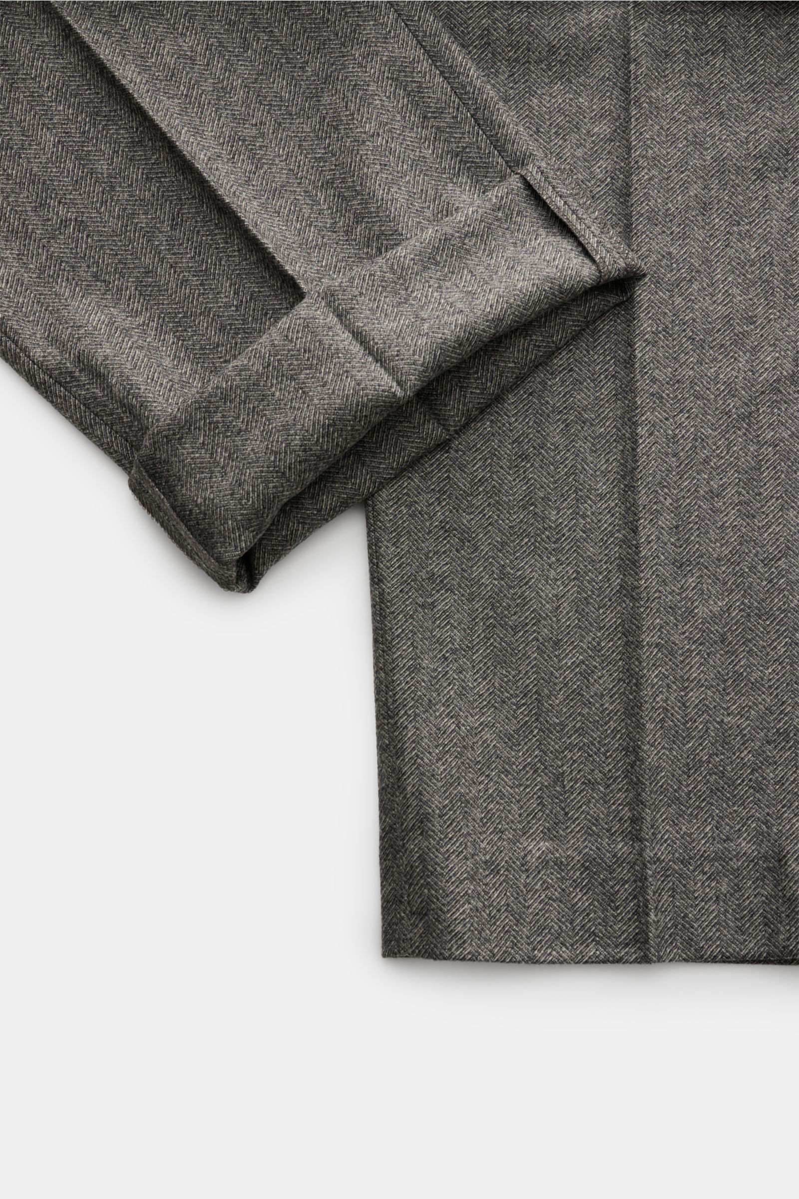 Close-up top-down view of the folded hem and fabric texture of PT Torino Wollhose 'Michael' dunkelgrau wool trousers with herringbone pattern.