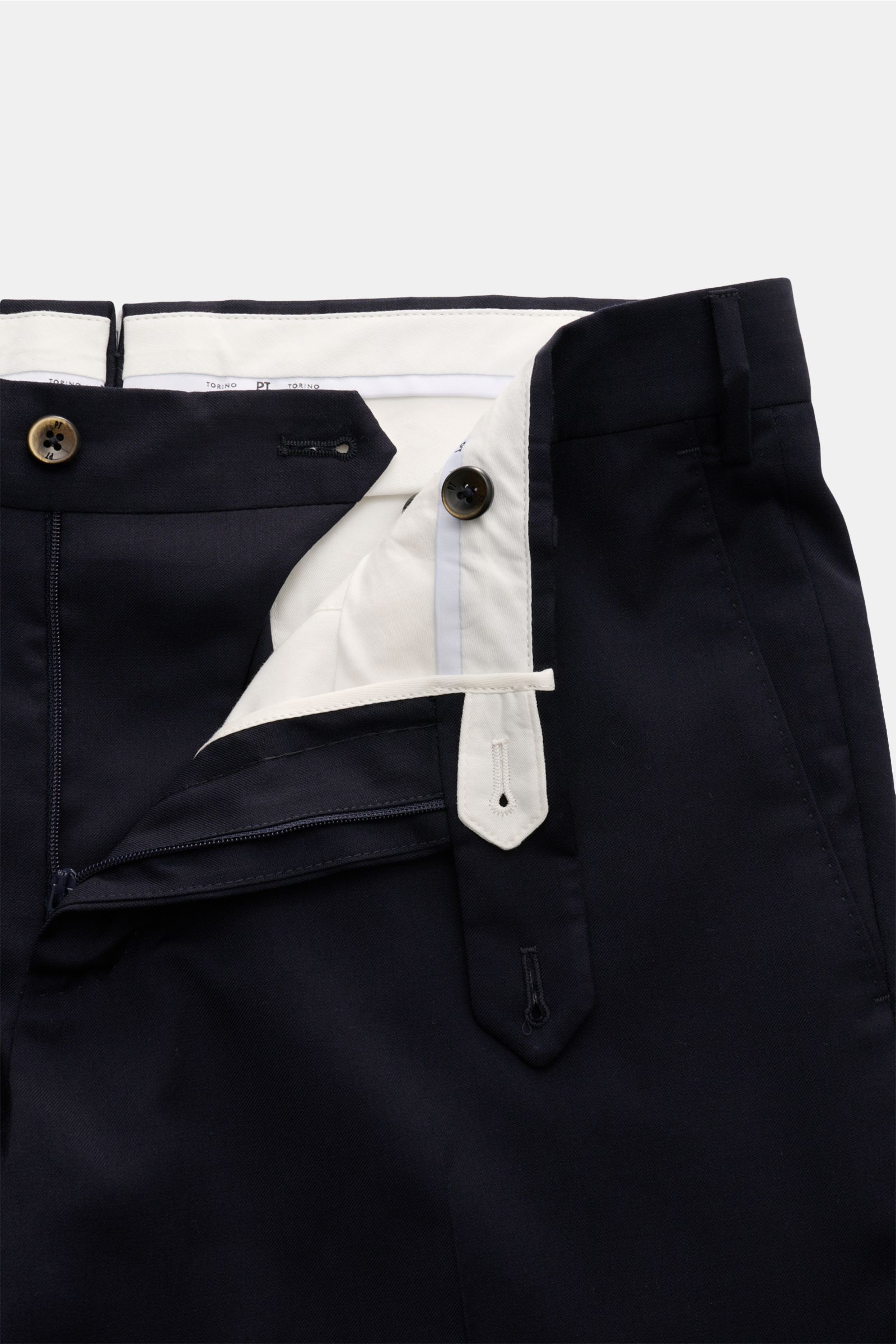 Close-up front view of PT Torino Wollhose 'Slim Fit' navy trousers showing fine twill pure wool fabric, soft touch, slim fit, tapered legs, zipper and waistband buttons, French pockets, small watch pocket, slim welt back pockets with button, and open leng