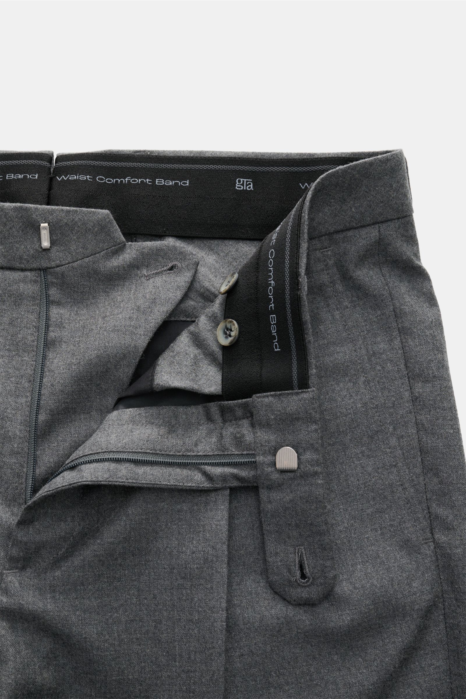 Close-up front view of the open waistband and zipper of GTA Wollhose 'Luca' dunkelgrau meliert, made of soft wool-cashmere blend with a patented Waist Comfort Band ensuring flexible fit and comfort. Features include smooth twill structure, tapered fit, re