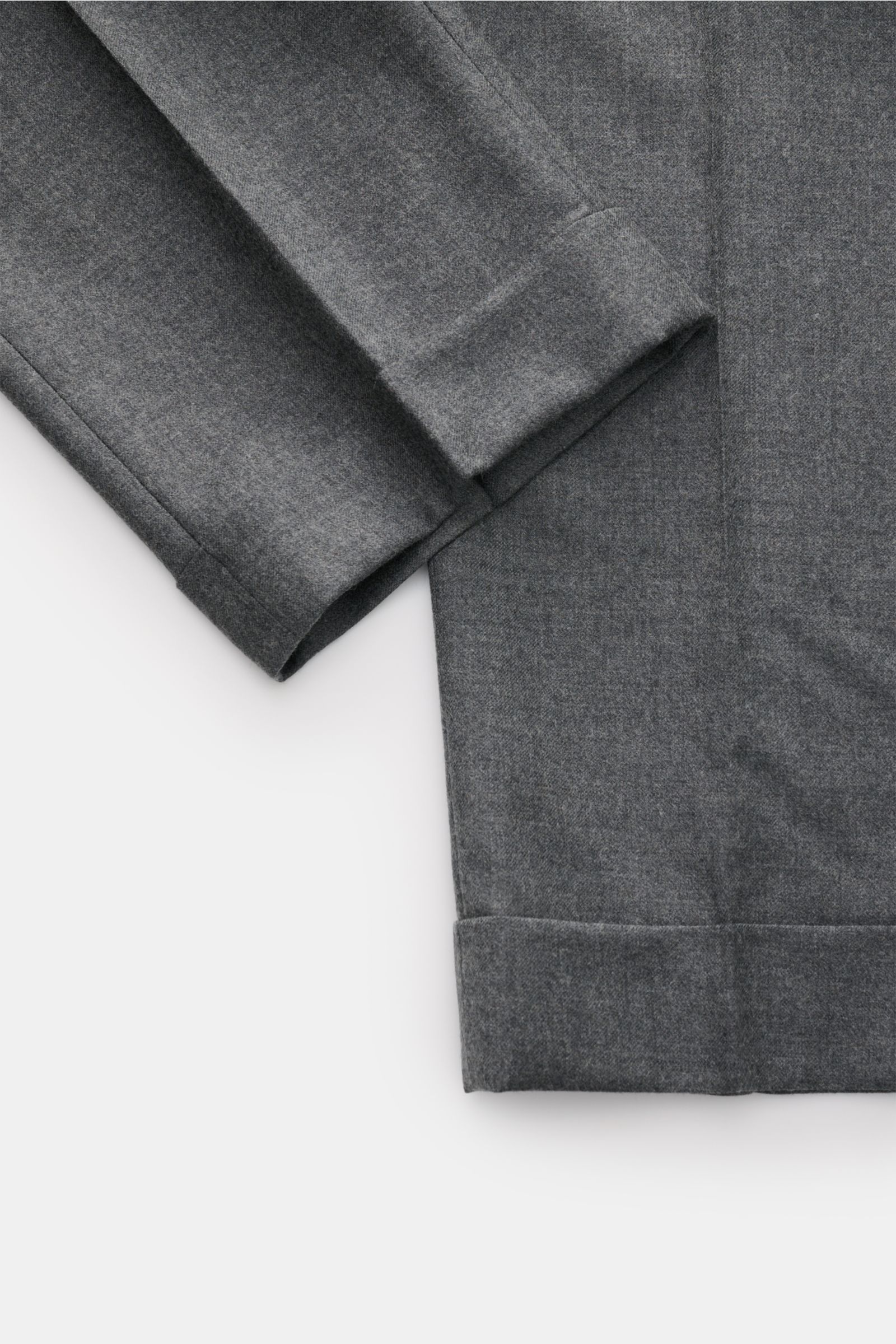 Close-up image of the lower legs of the GTA Wollhose 'Luca' dunkelgrau meliert, photographed from above, highlighting the smooth, fine twill structure, tapered fit, ankle-length cut with fixed cuffs, and soft wool-cashmere blend fabric.