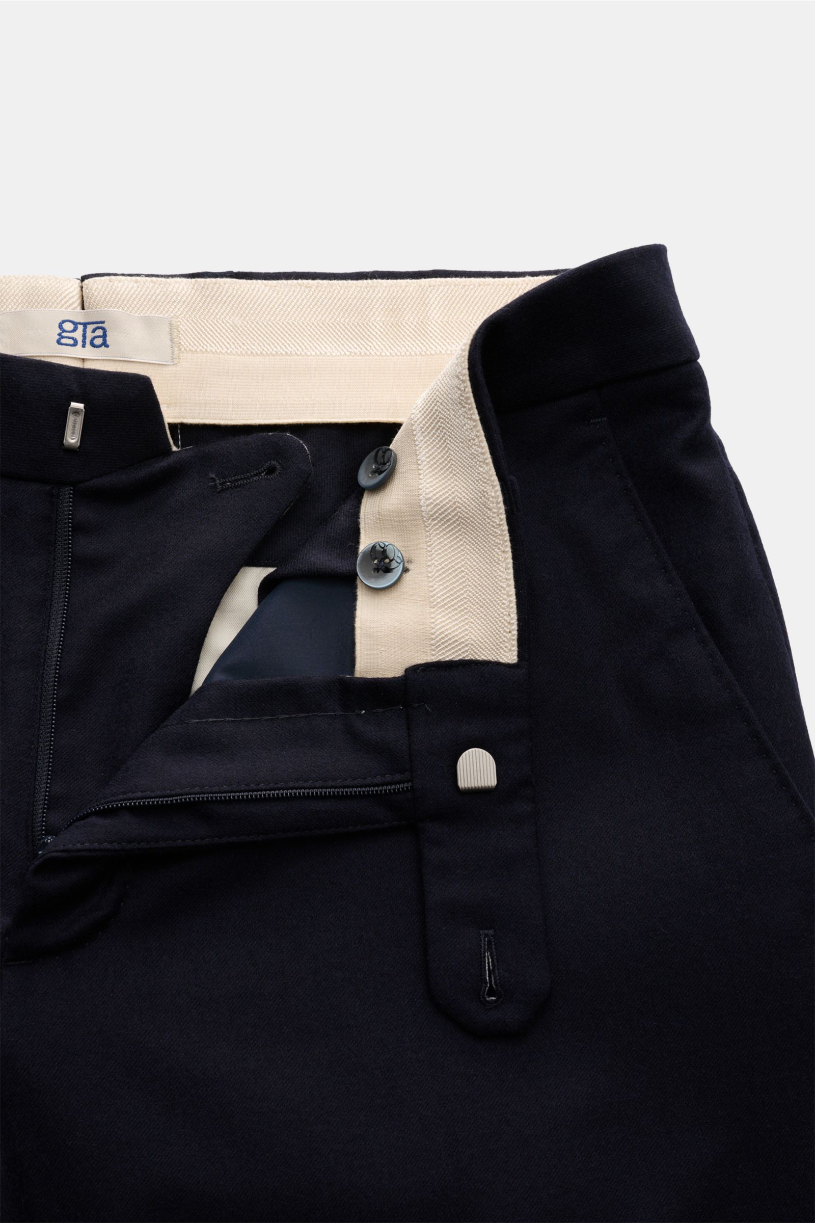 Close-up front view of the GTA Wollhose 'Federico' navy showing open zipper, bundknopf, elastic waistband insert, reine Wolle, leicht elastische Qualität, weicher Griff, leichte Qualität, Regular Fit, leicht schmal zulaufend, französische Taschen, paspeli